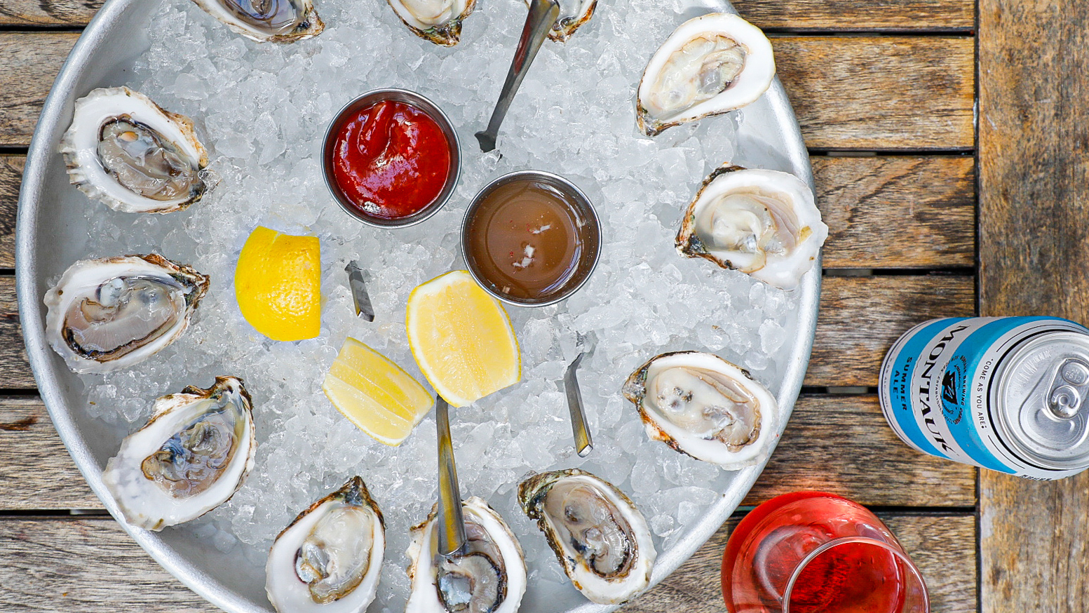 oysters in a tray with lemon and different sauces
