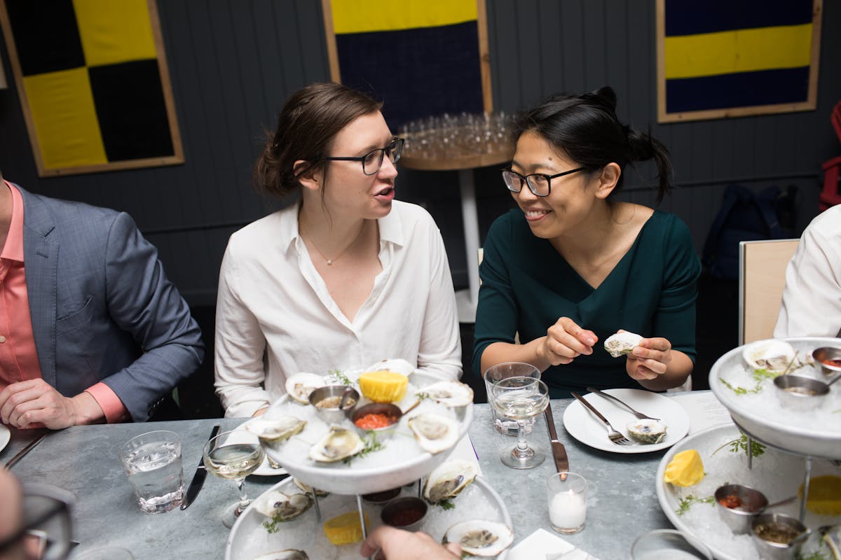 a group of people sitting at a table with a plate of food