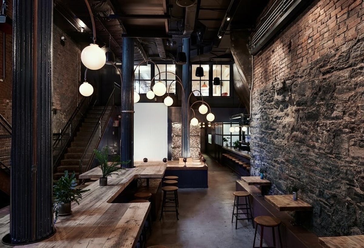 a stone building that has a clock at the top of a wooden table