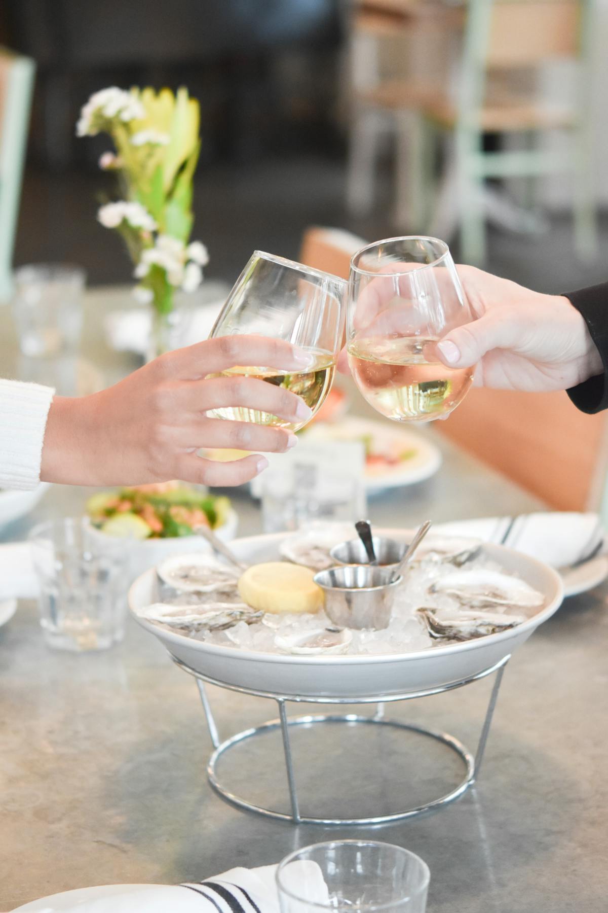 a woman sitting at a table with wine glasses