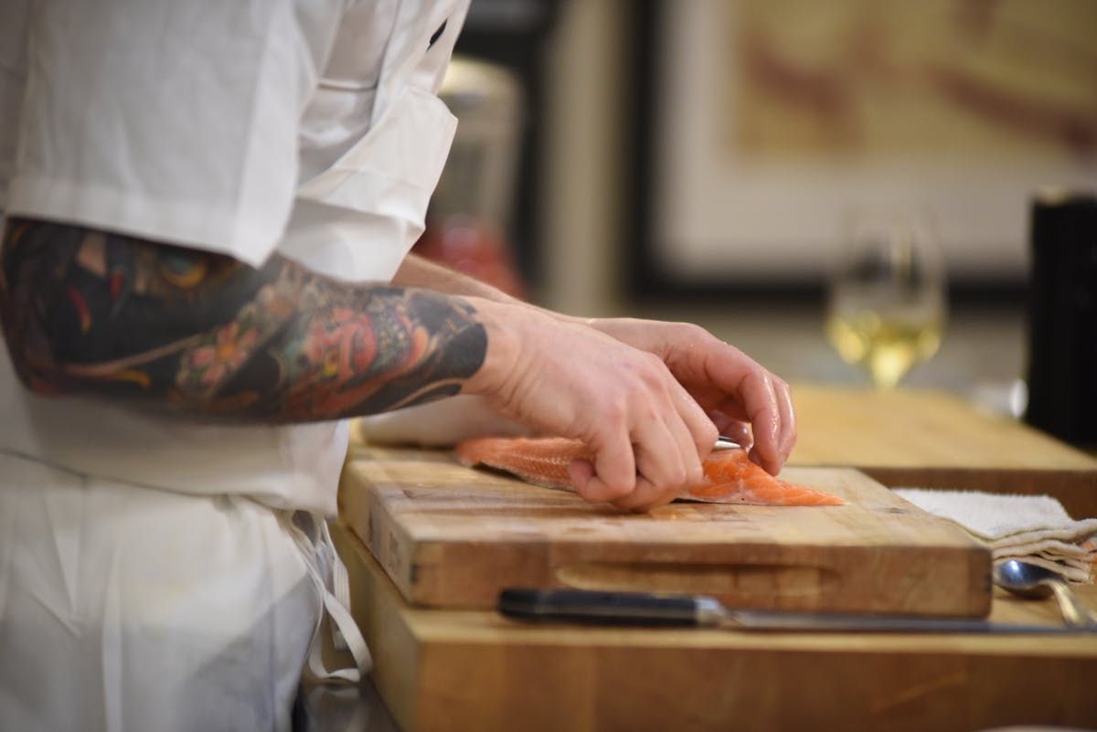 a person sitting on top of a wooden cutting board