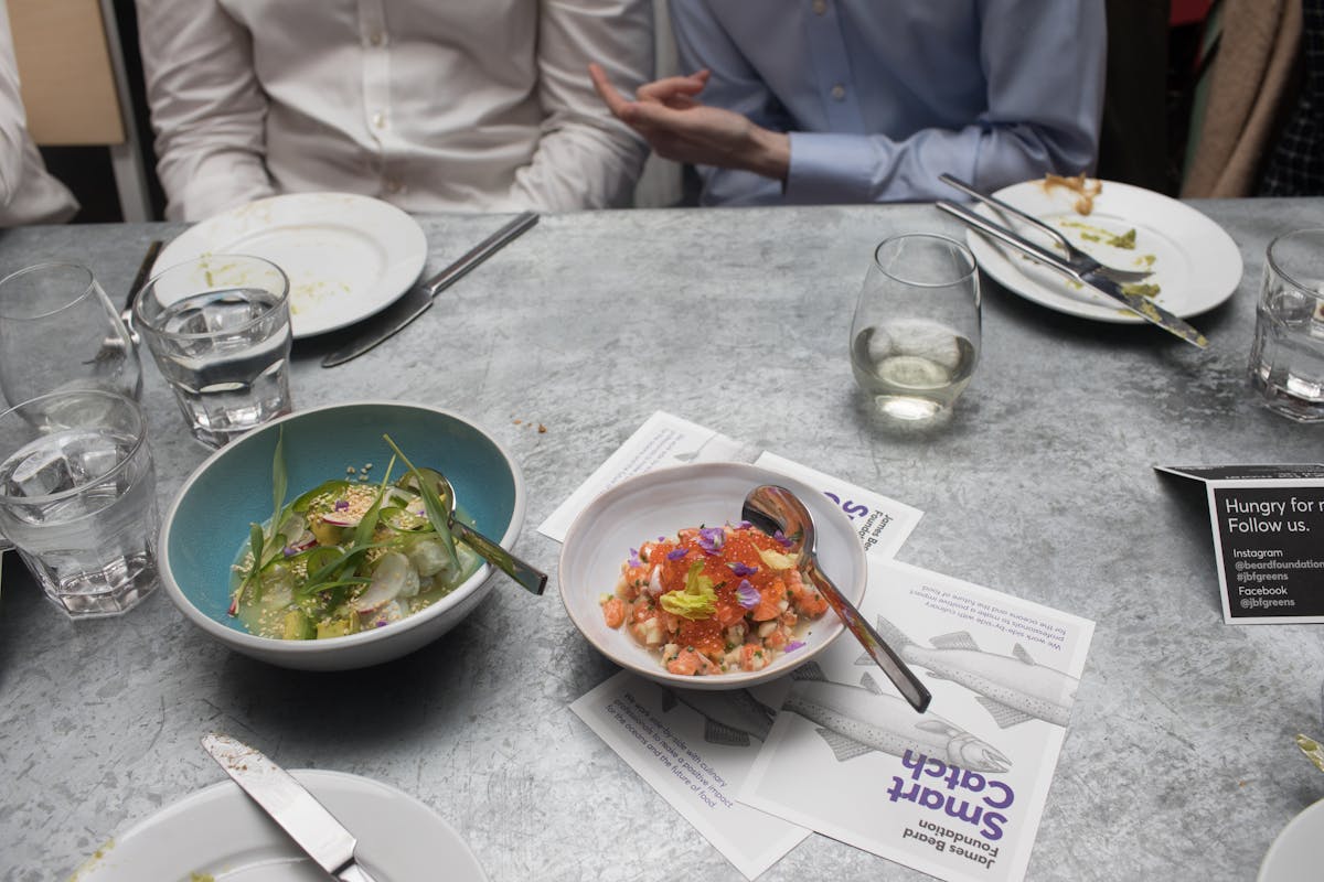 a group of people sitting at a table with a plate of food