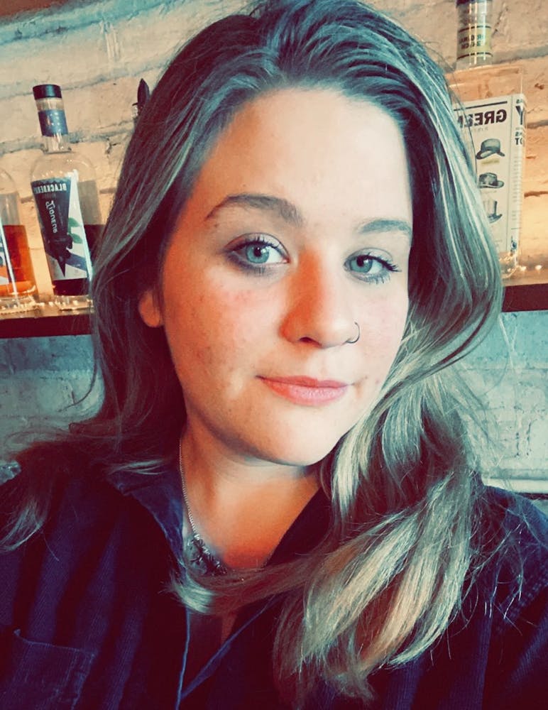 a man wearing a hat and smiling at the camera