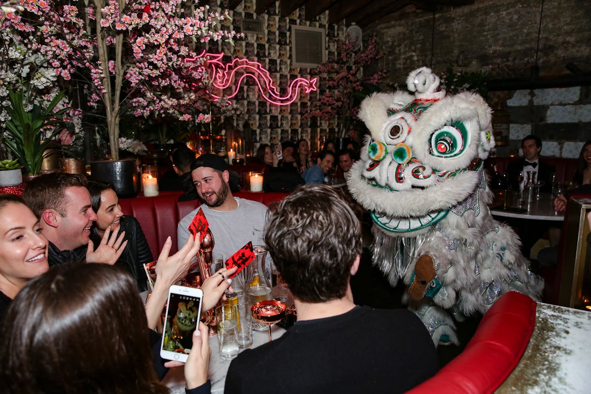 a Chinese dragon entertaining a group of people at a dining table