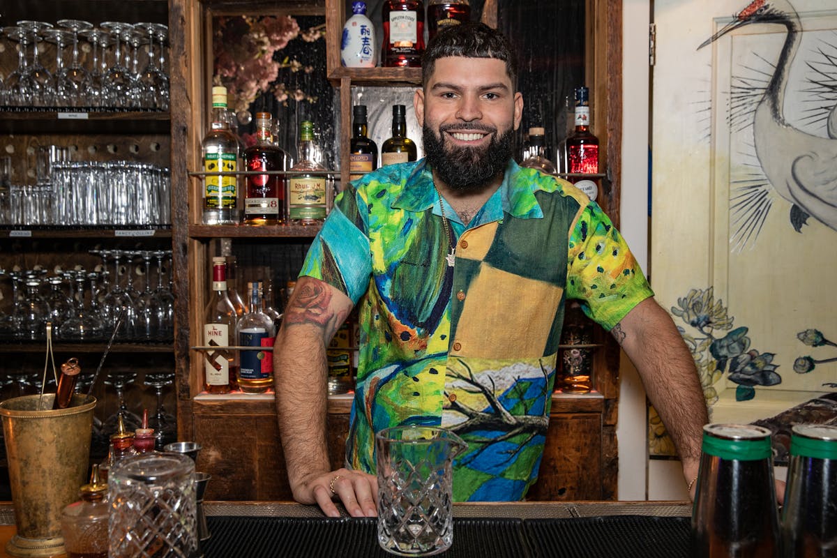 a man with short hair wearing a tropical shirt smiling