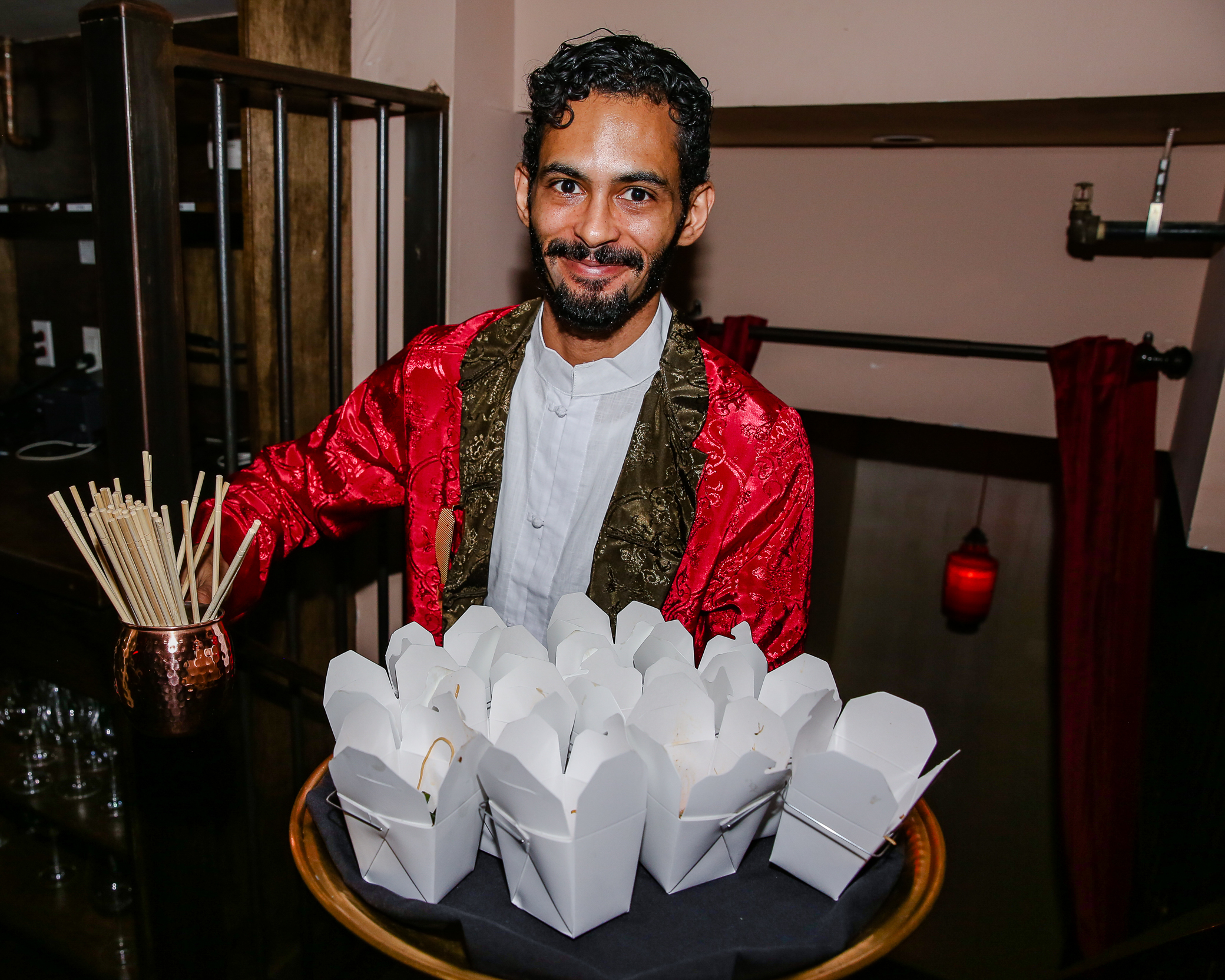 a man serving food on a gold serving tray