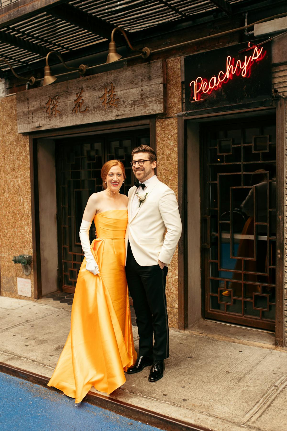a bride wearing a dress and a groom wearing a suit standing in front of a restaurant
