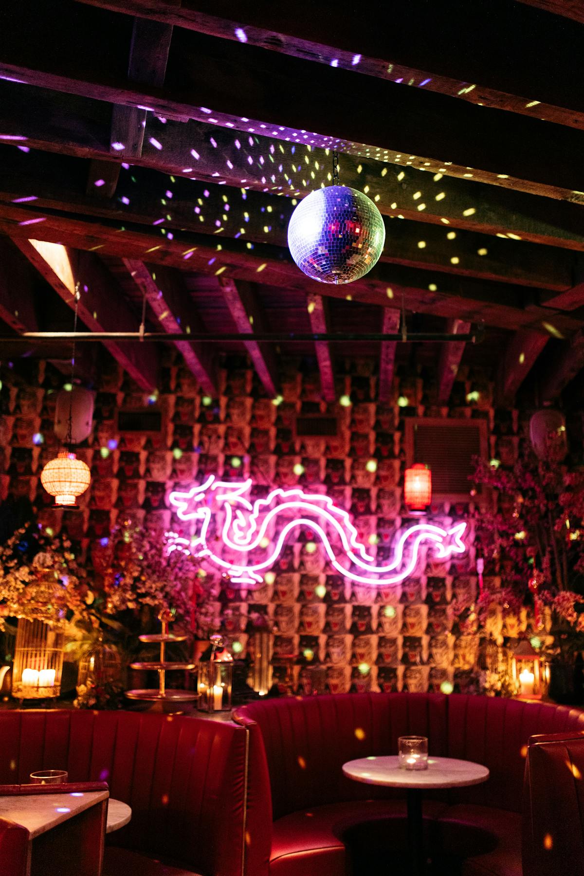 a cocktail bar with disco lights, candles, and neon sign