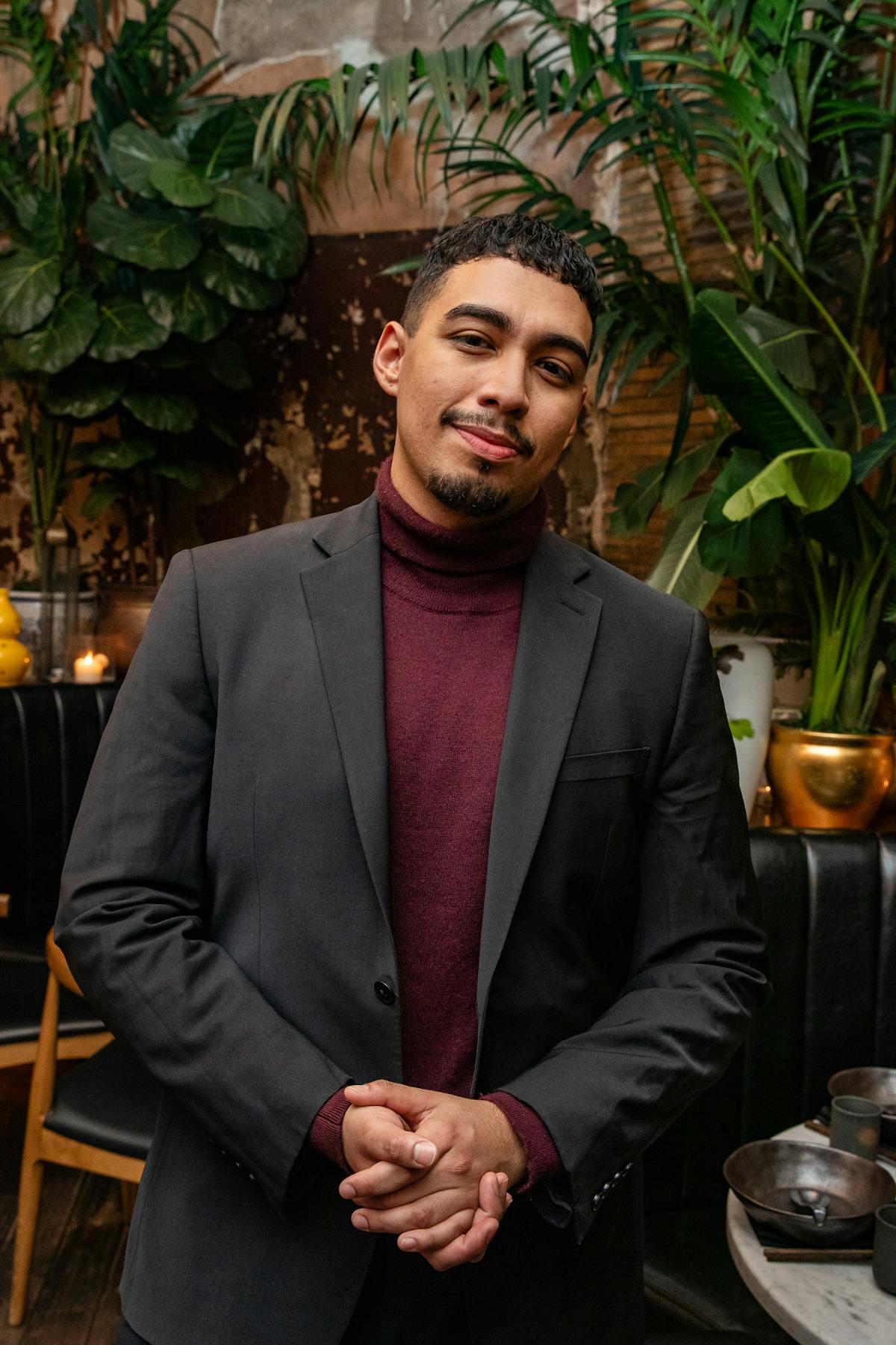 a man with short hair wearing a gray suit smiling
