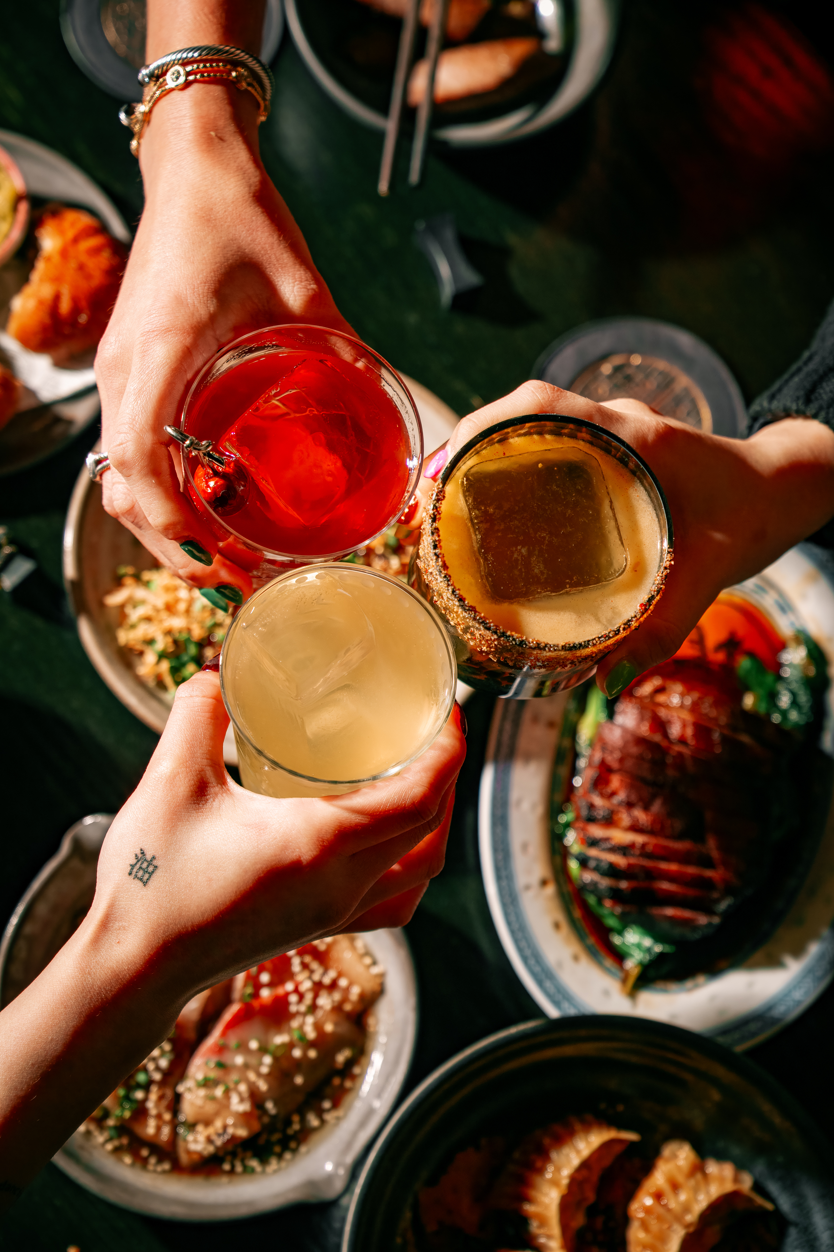 a group of hands holding drinks