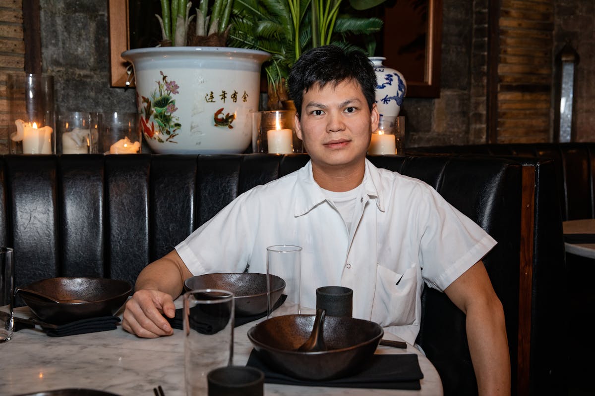 a man with short hair wearing a white chef shirt smiling