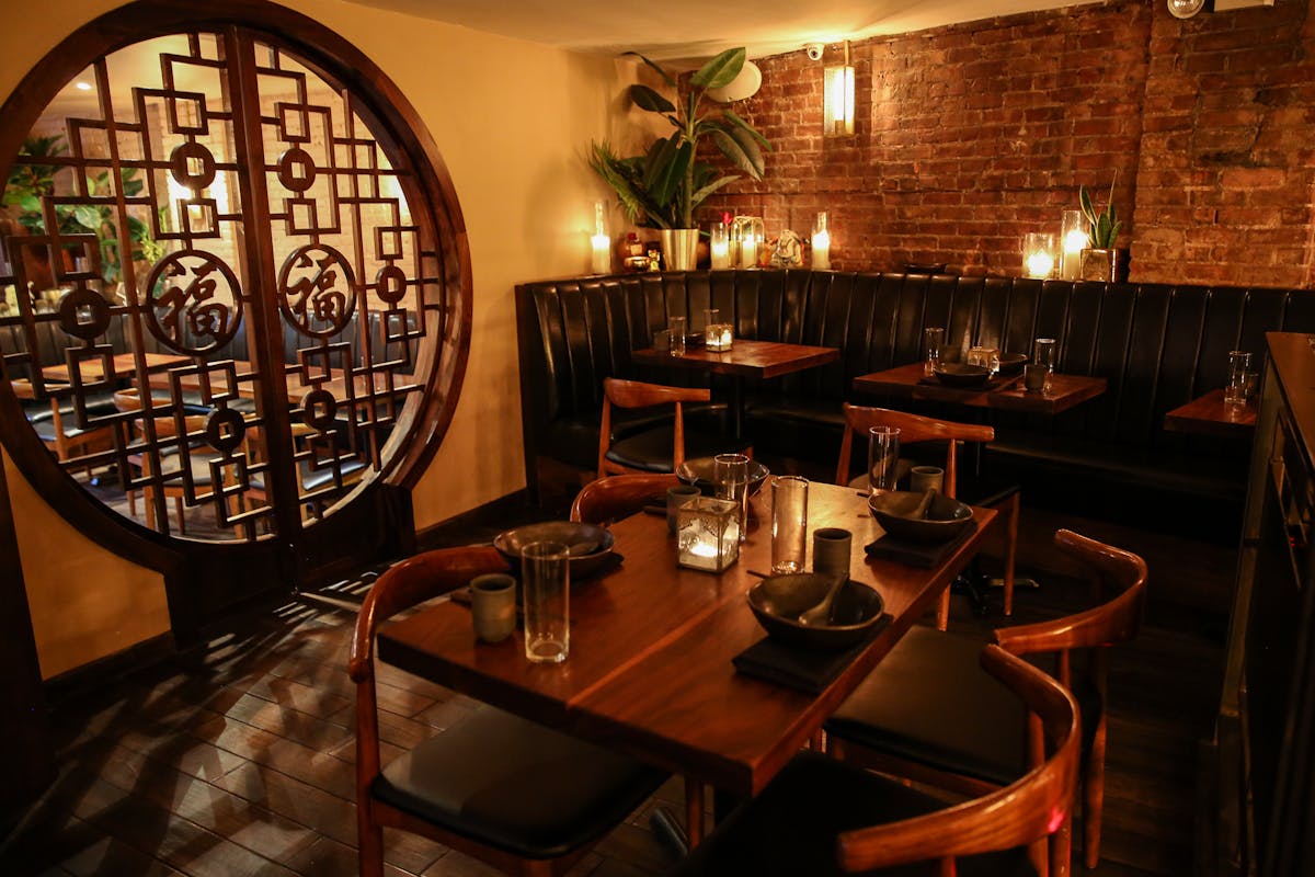 a private dining room with tables, chairs, booths, and candles