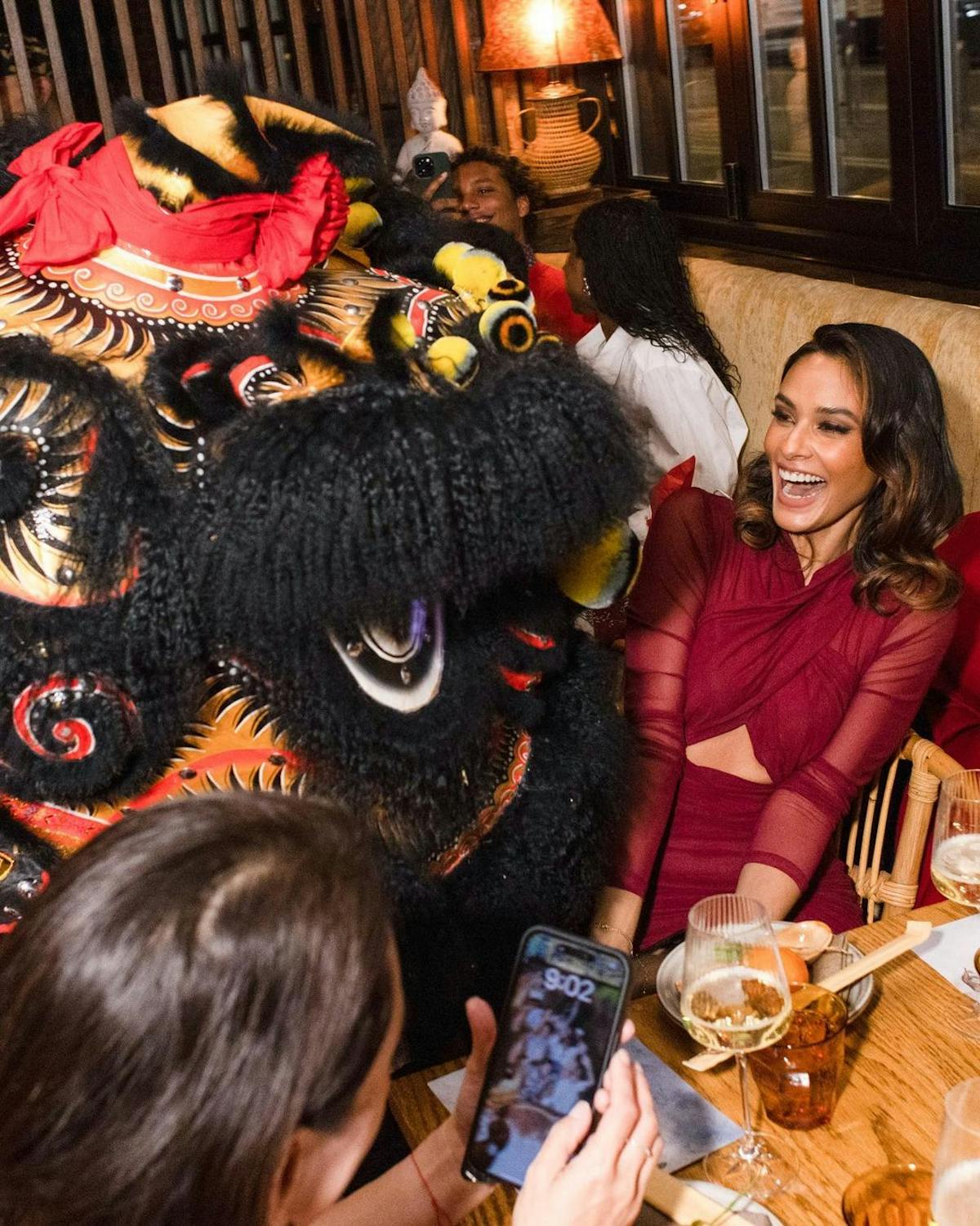 a Chinese dragon entertaining a group of people at a table