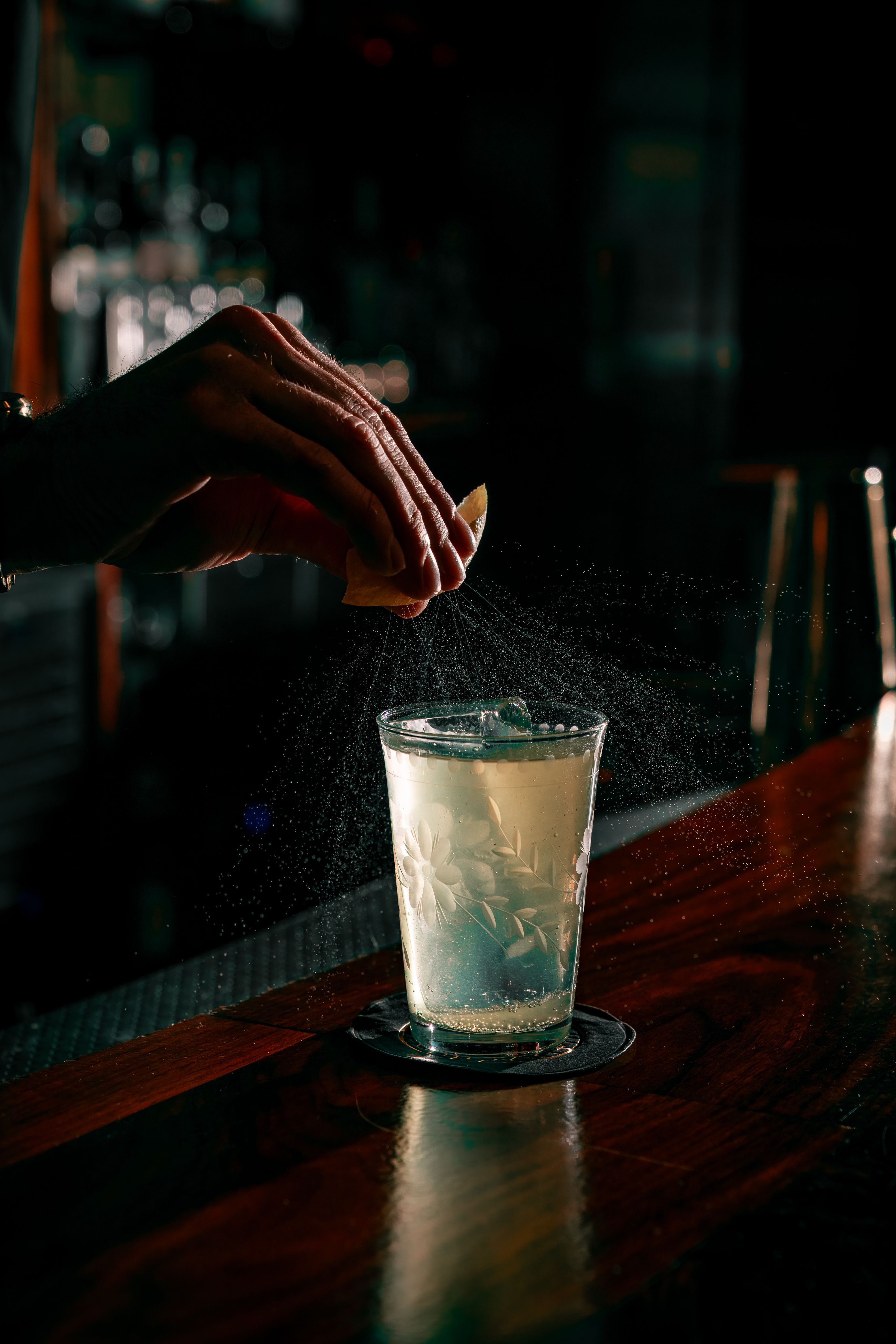 a person squeezing a lemon into a glass