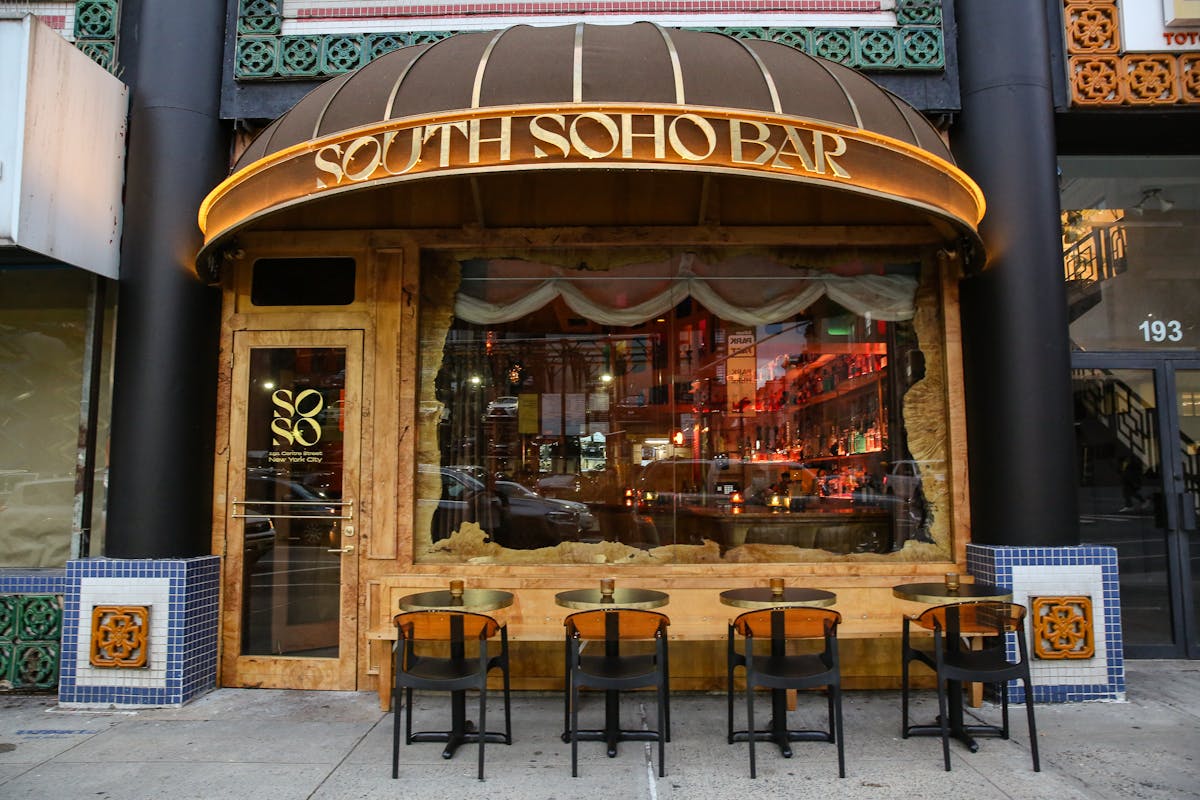 an exterior of a cocktail bar with wood decor and tables and chairs
