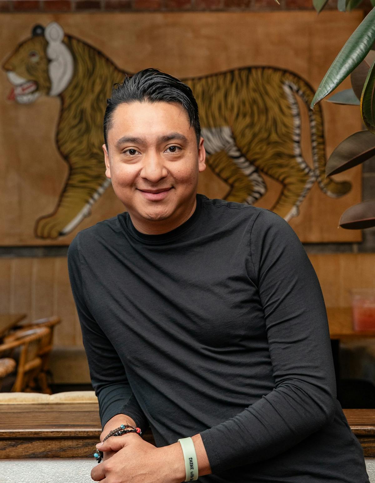 a man with short hair wearing a black long sleeve shirt smiling