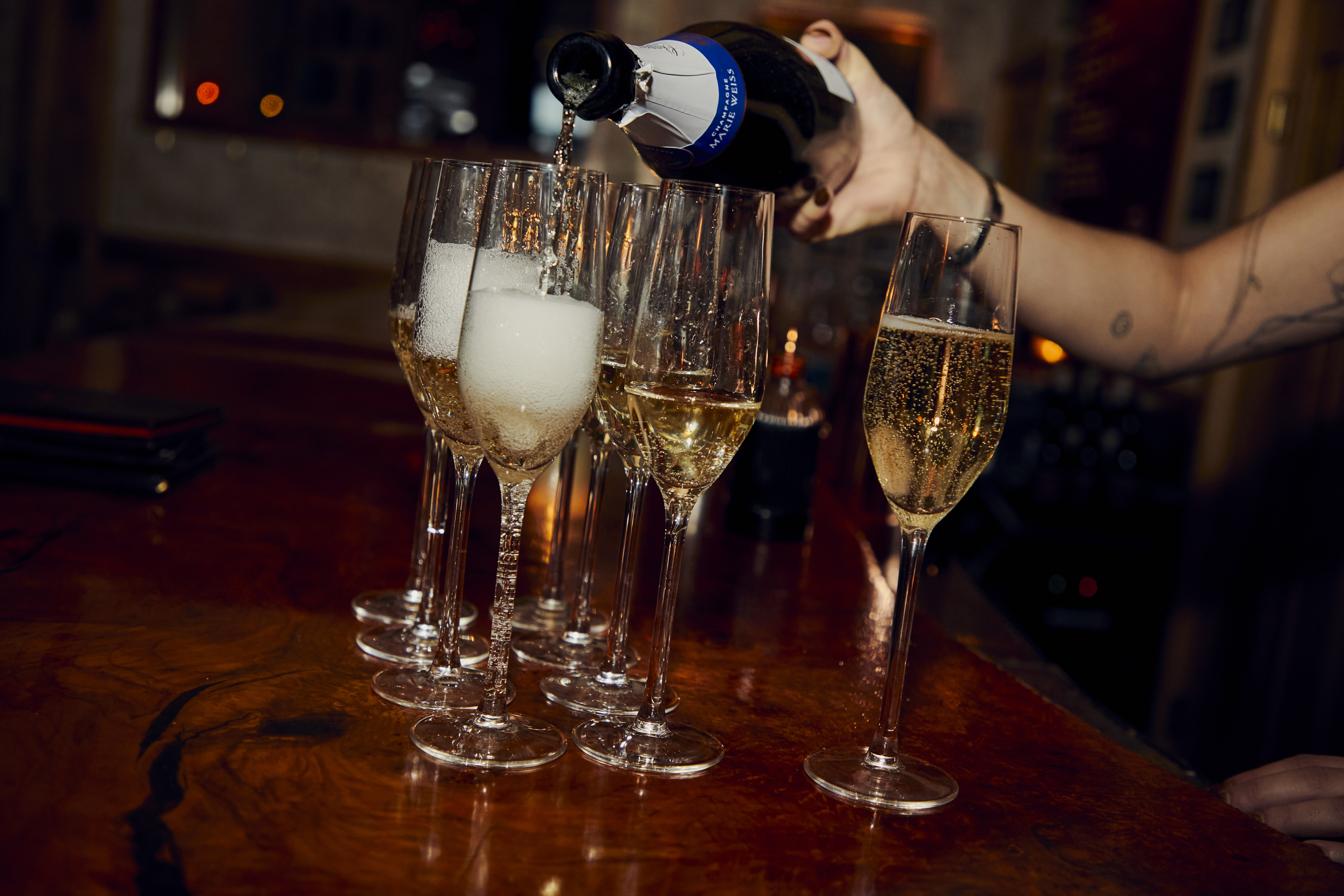 a person pouring champagne into glasses