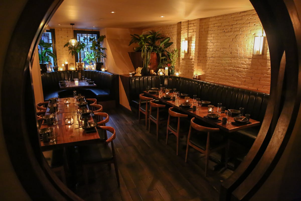 a dining room with long booths, tables, chairs, and candles