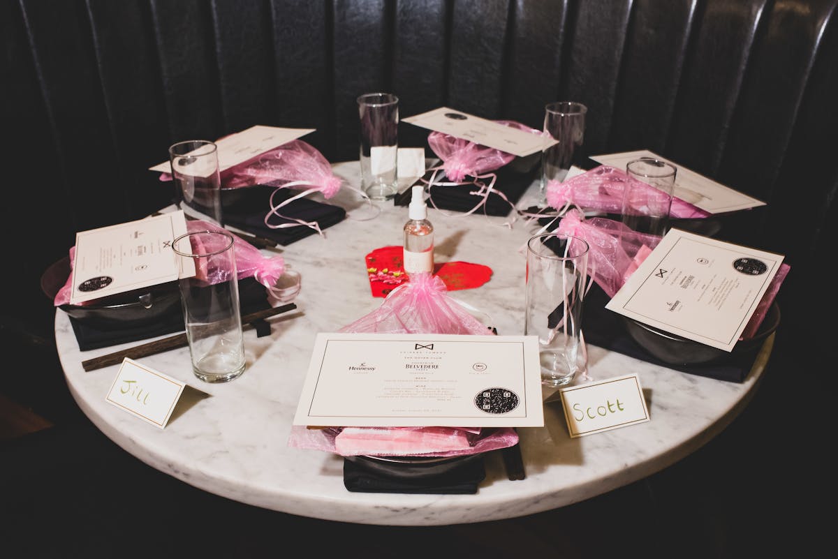 a marble table with pink and black table settings