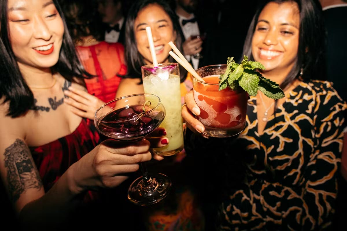 a group of woman with cocktails doing a cheers