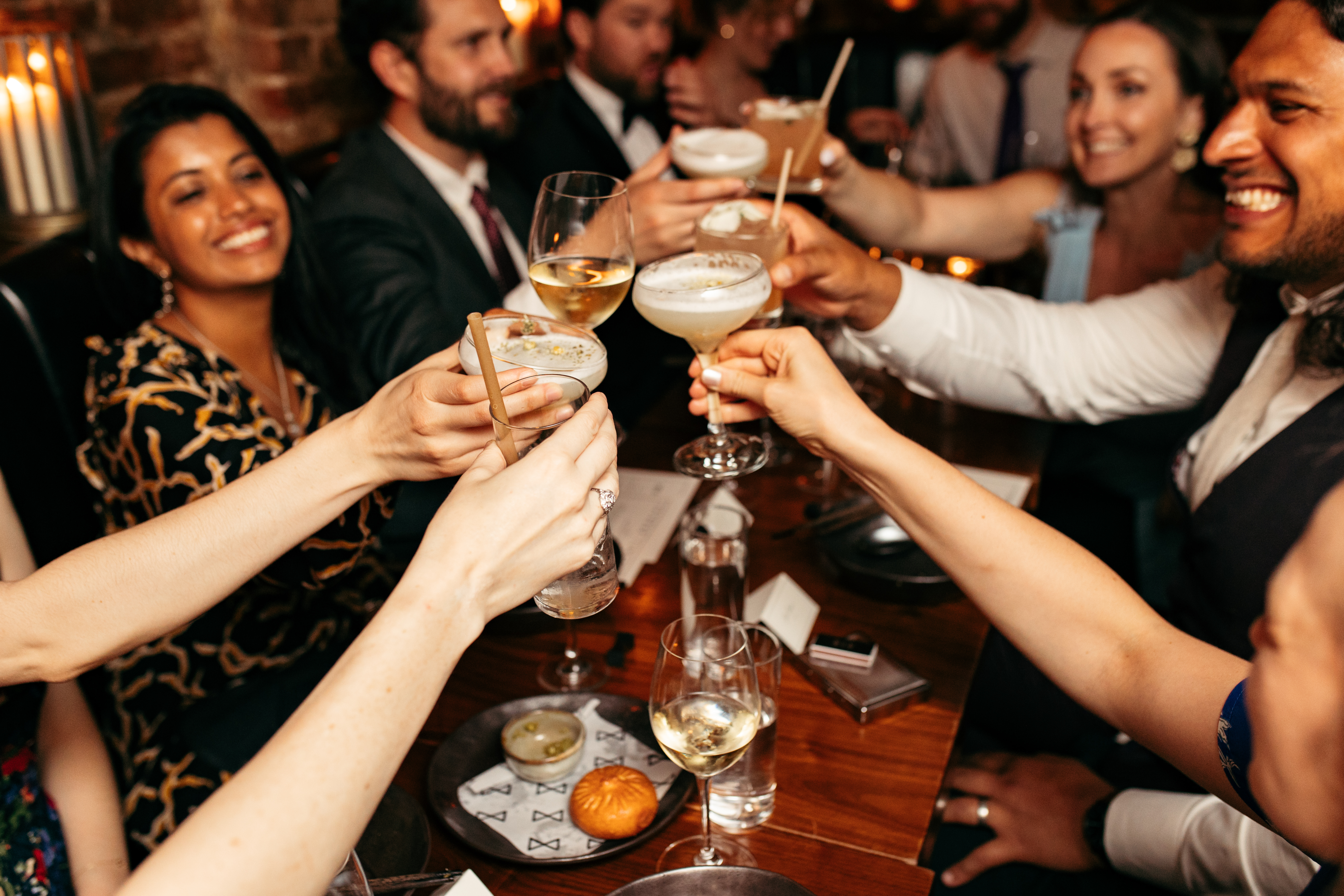 a group of people with cocktails doing a cheers