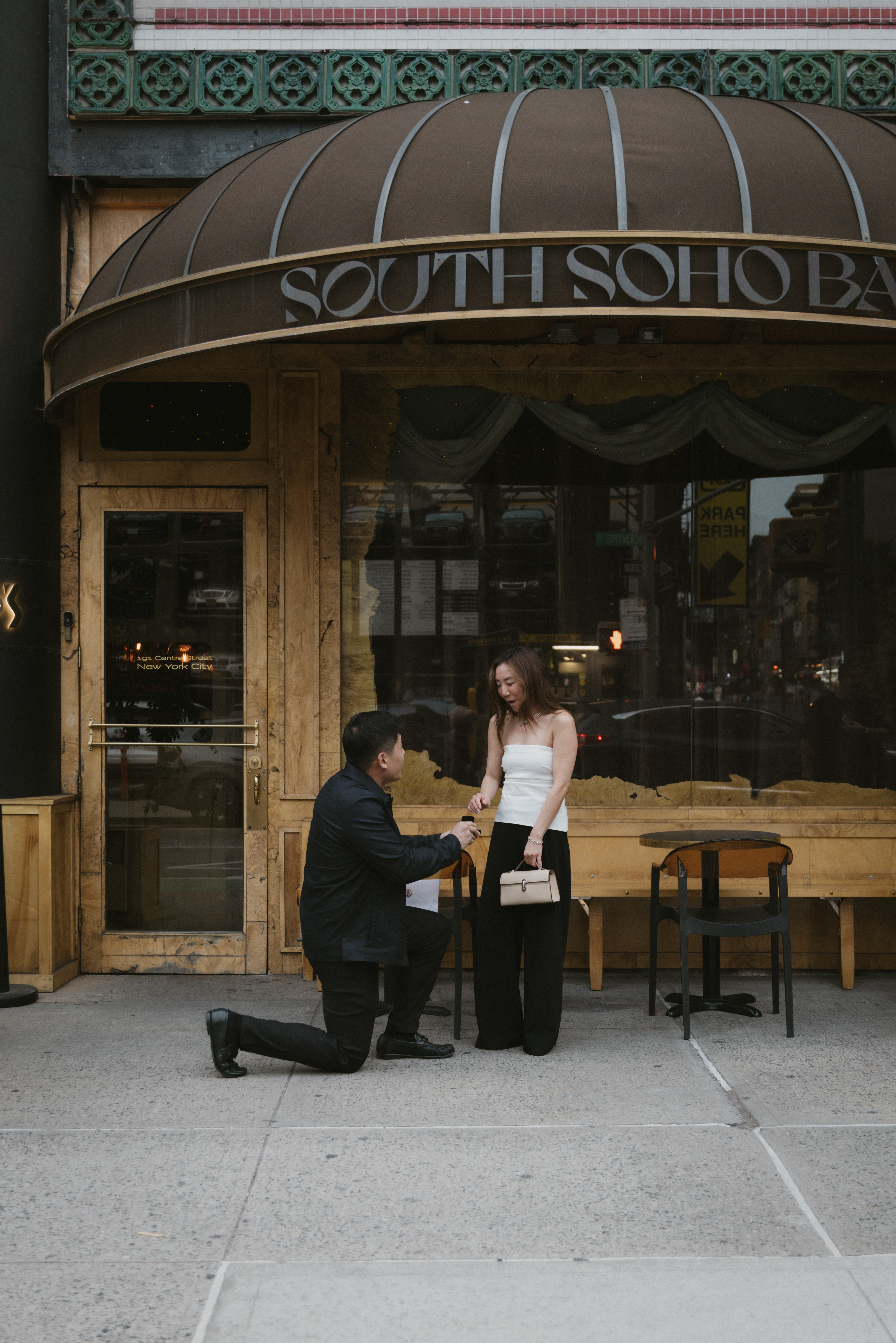 a person sitting on a bench in front of a building