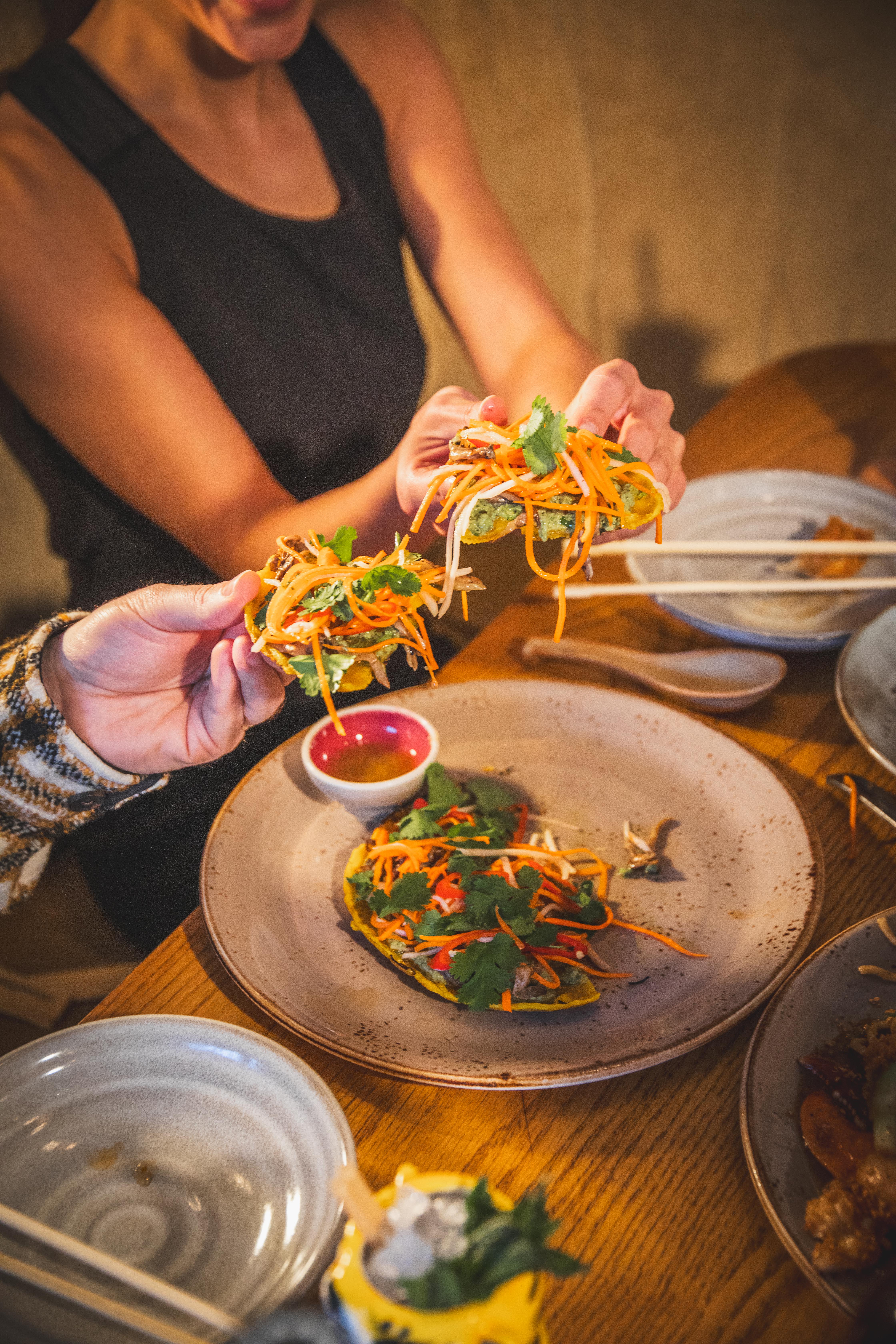 a person holding food over a plate