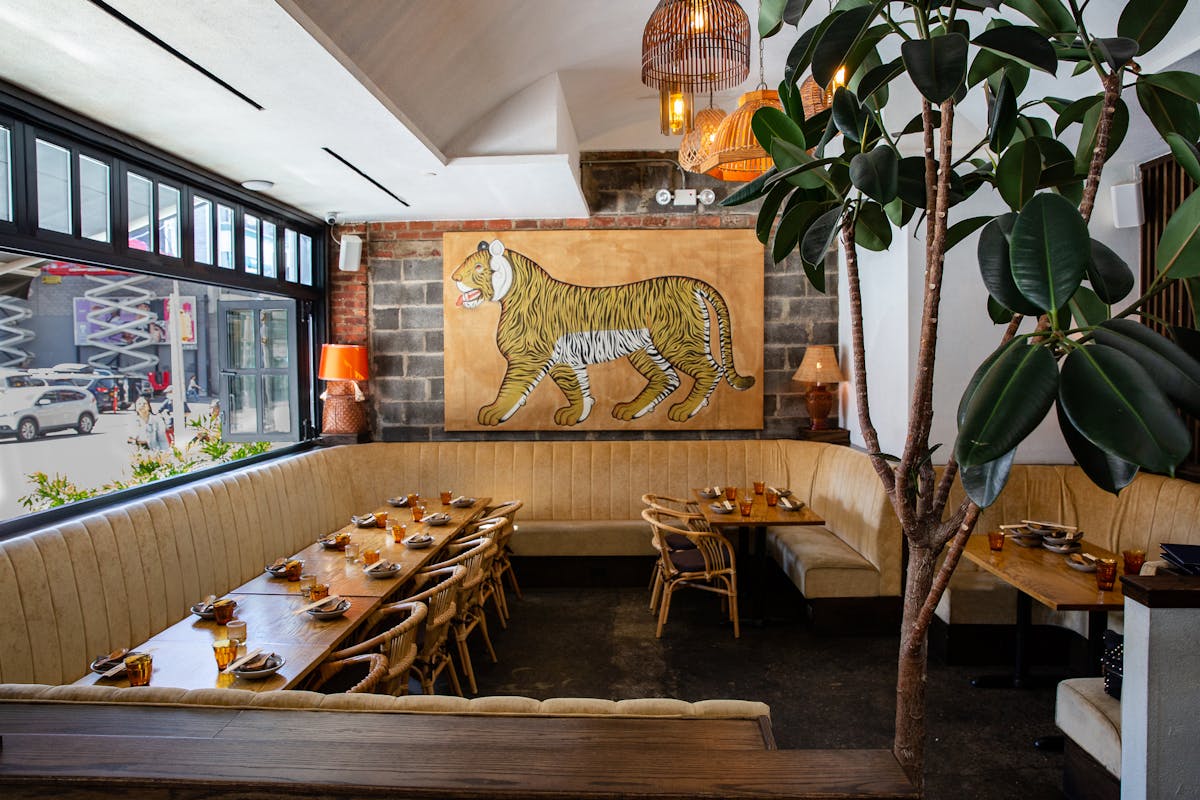 a dining room with booths, tables, chairs, and a tiger art