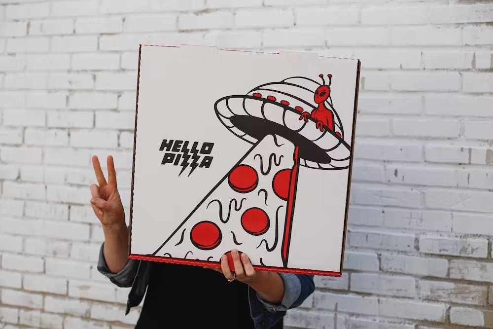 a hand holding up a sign in front of a brick wall