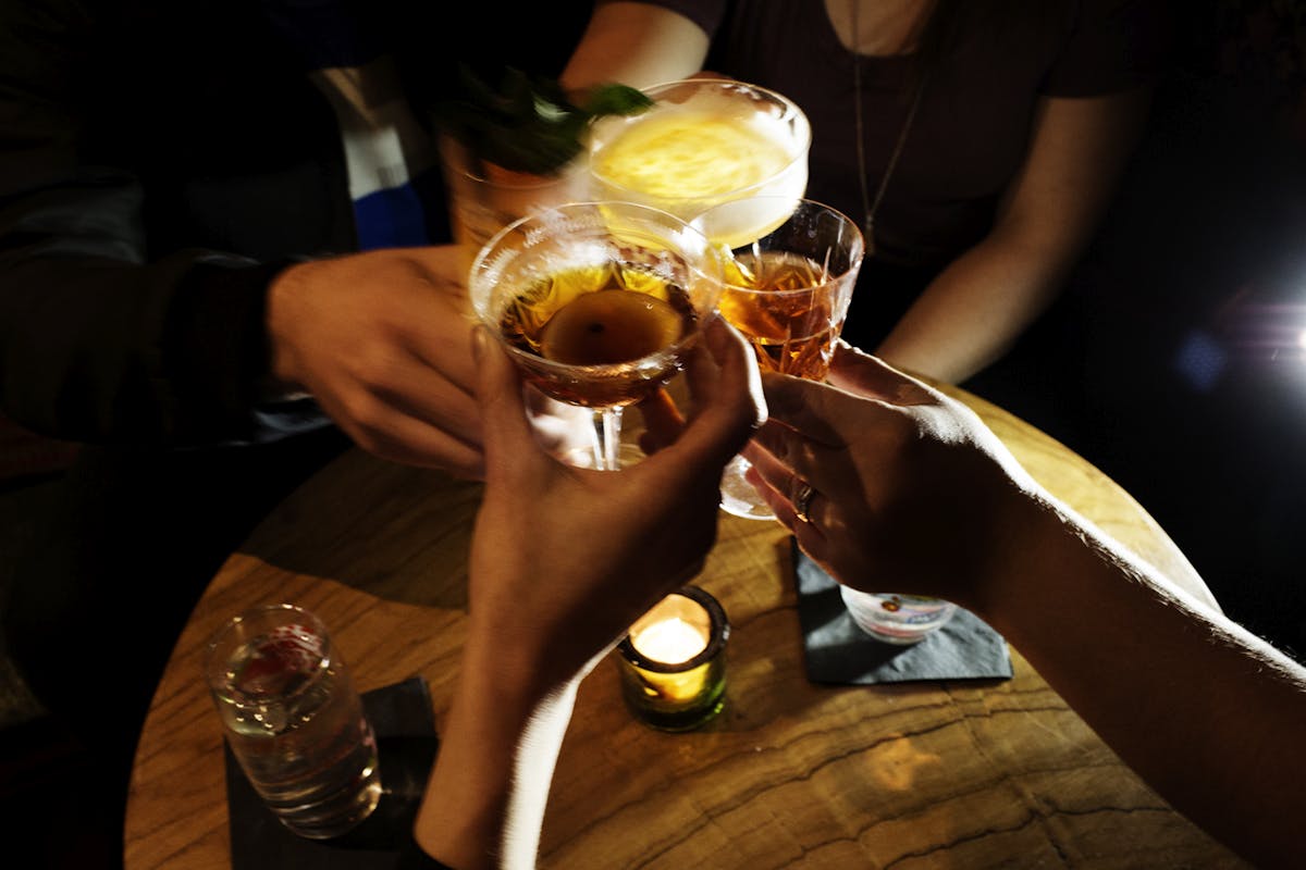 a person drinking a glass of beer on a table