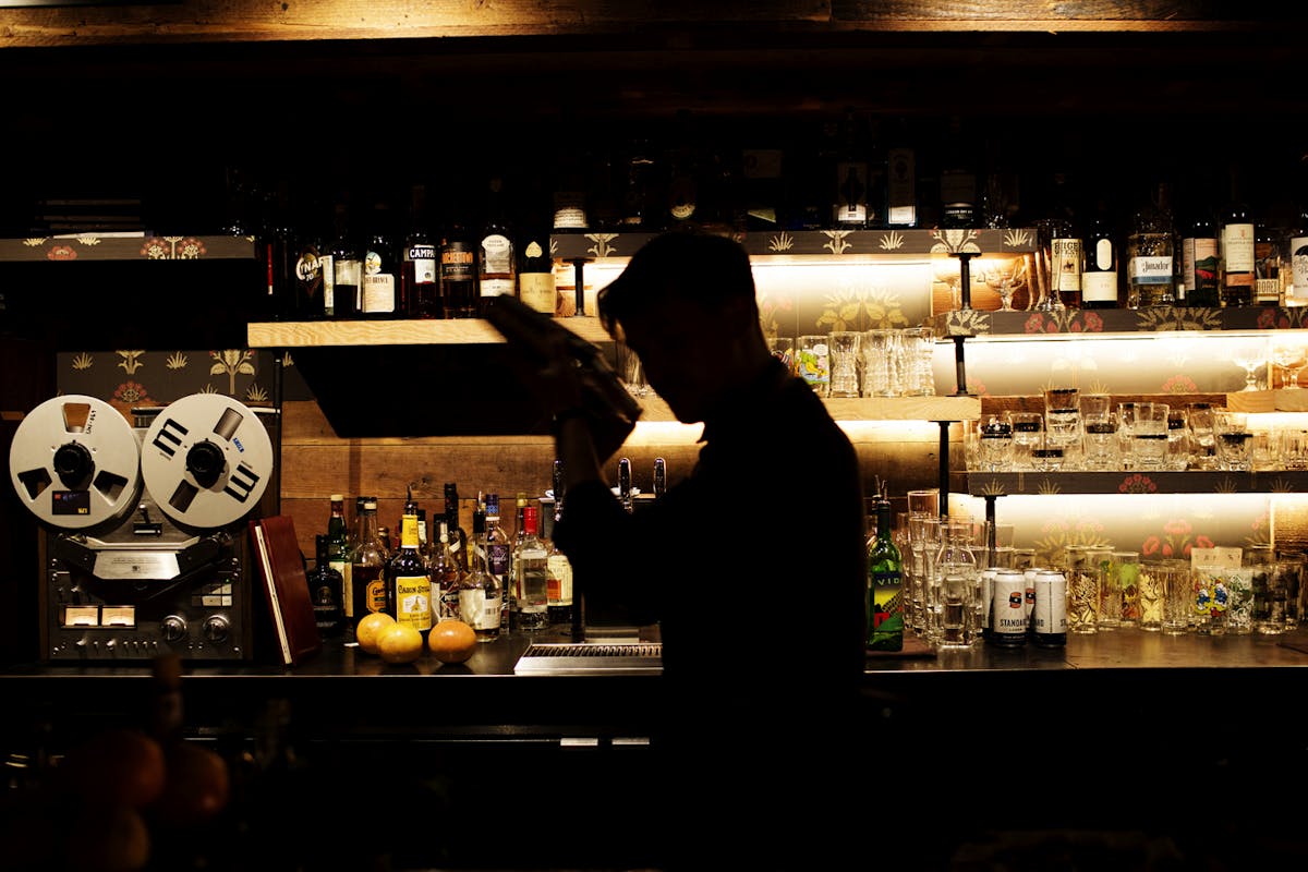 a back bar bartender shaking a cocktail
