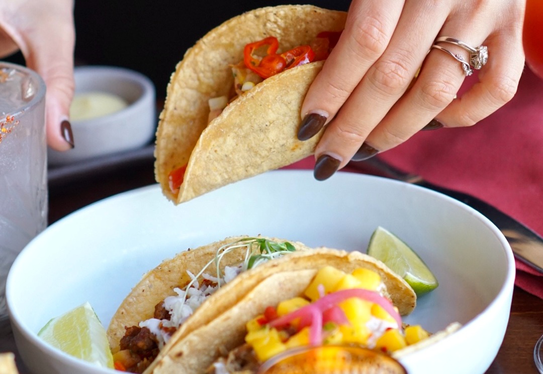 a close up of a person holding a plate of food on a table
