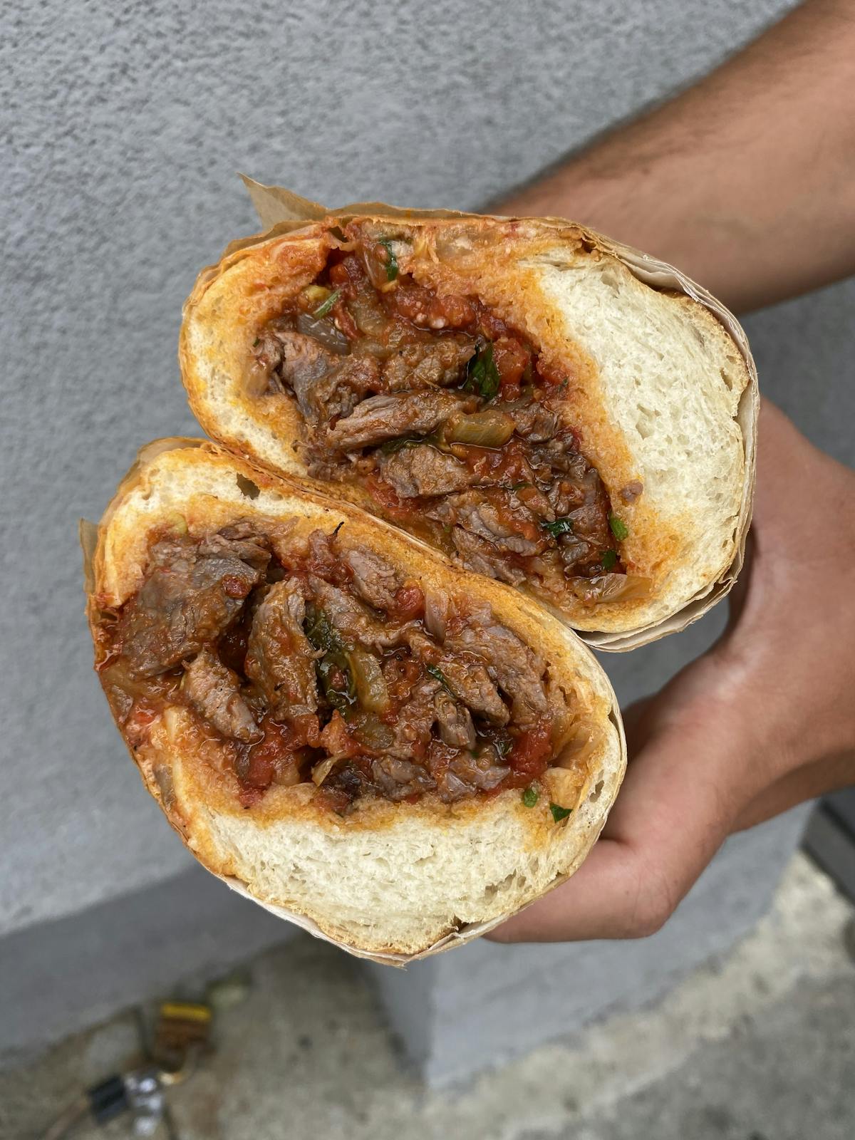 a hand holding a piece of bread
