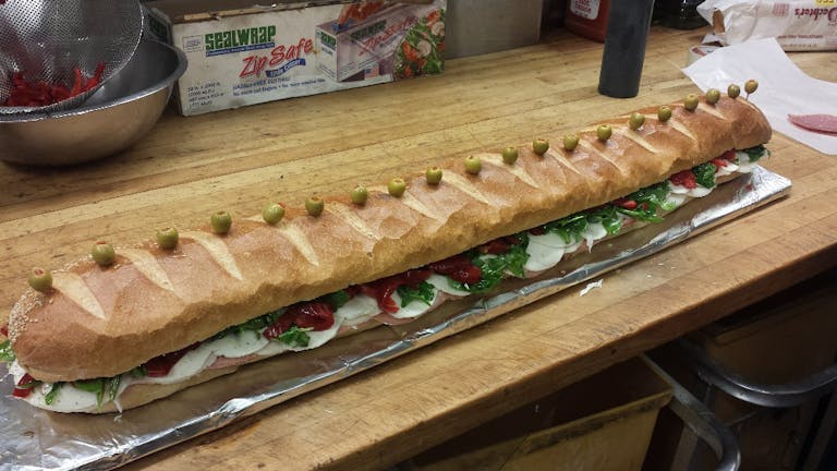 a cut in half sandwich sitting on top of a wooden cutting board