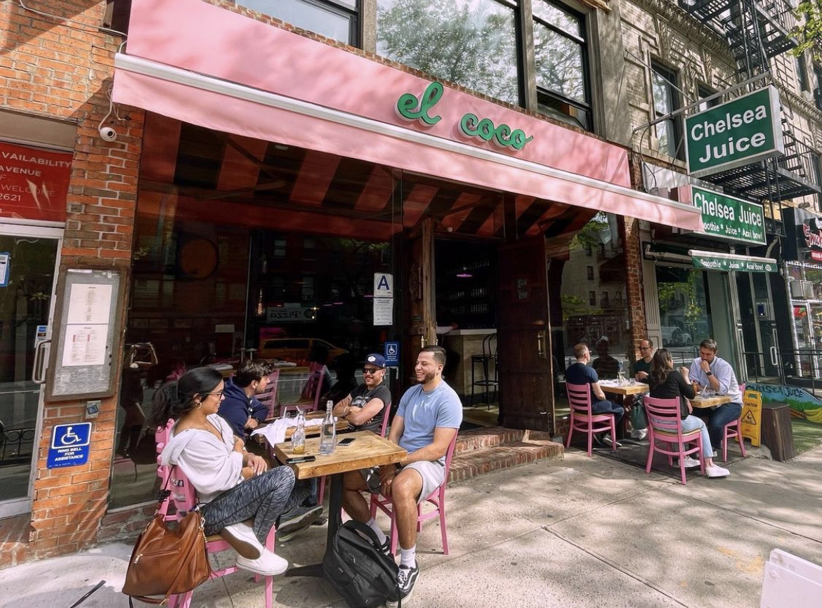 a group of people walking down a street in front of a store