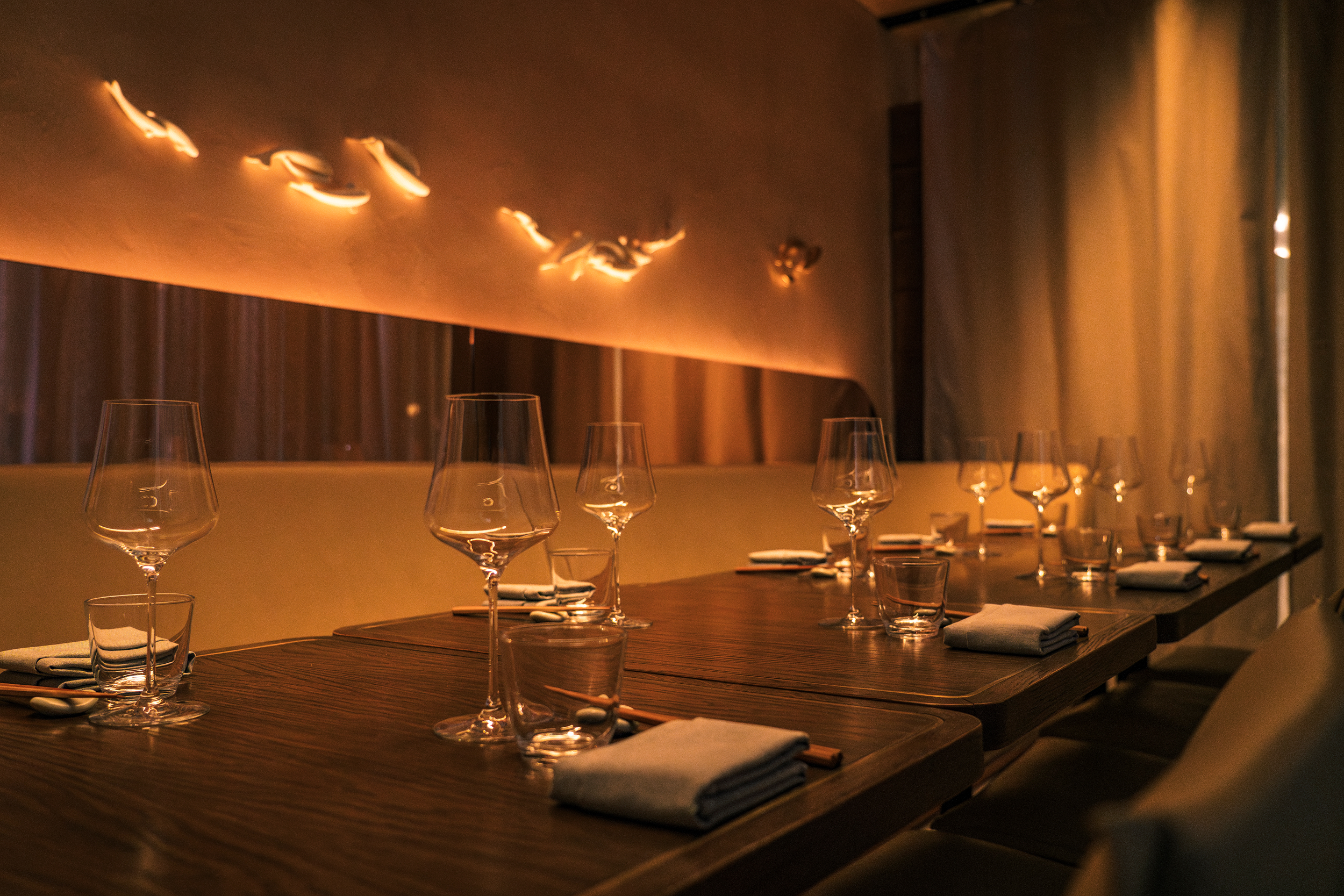 a table with wine glasses and napkins