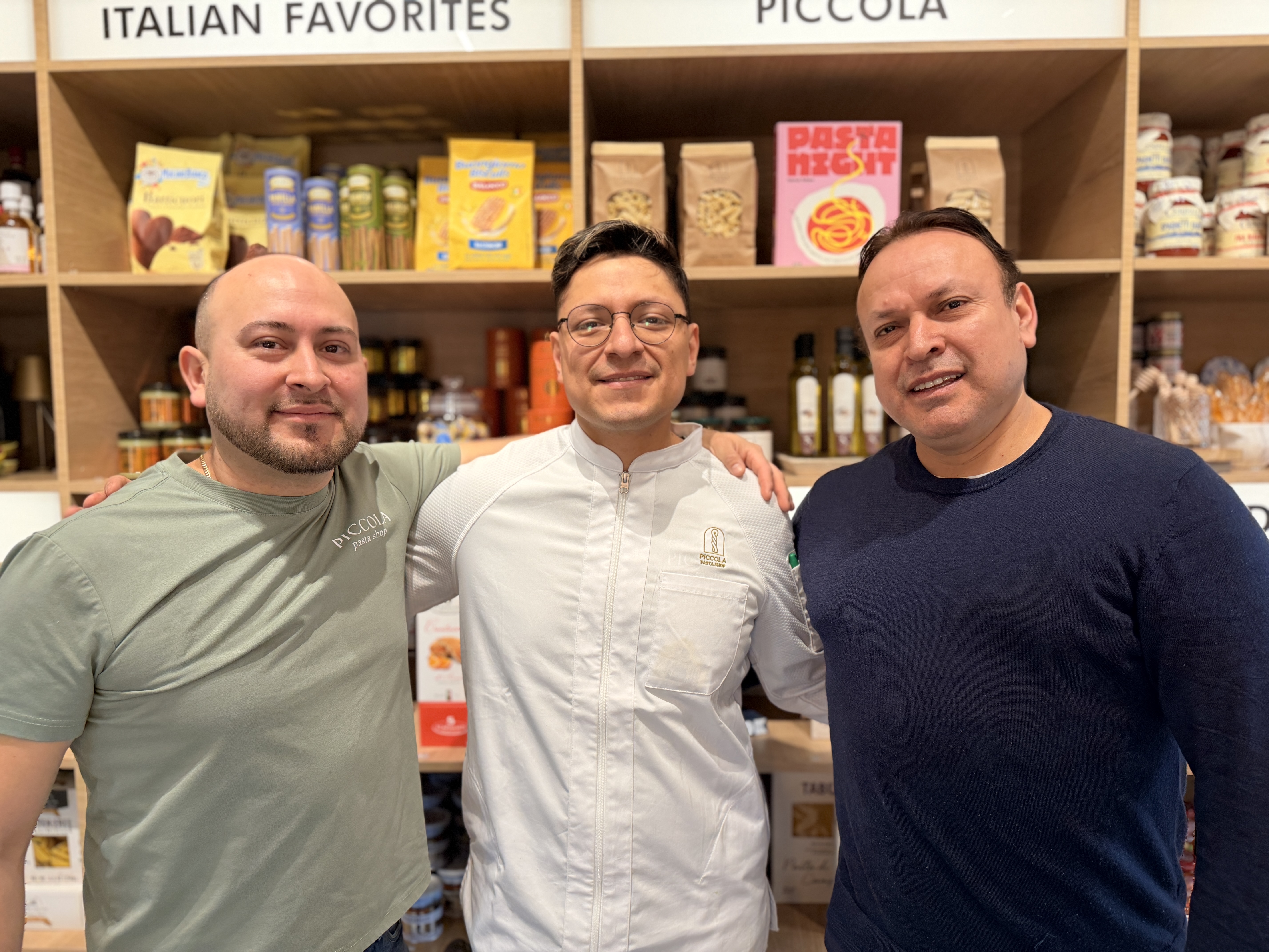 a group of men standing in front of a shelf of food