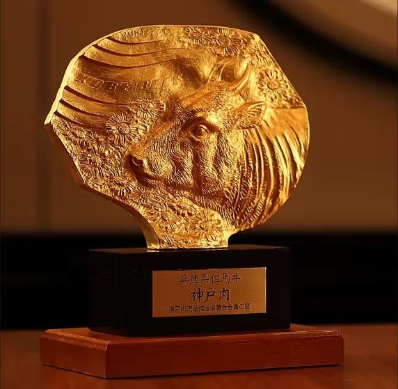 A golden bull award is prominently displayed on a polished wooden table, showcasing its gleaming surface and intricate details