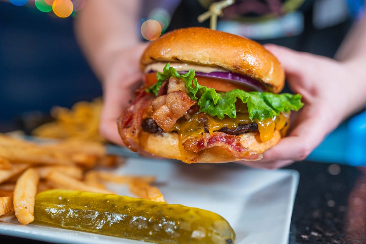 a close up of a person holding a hot dog on a bun