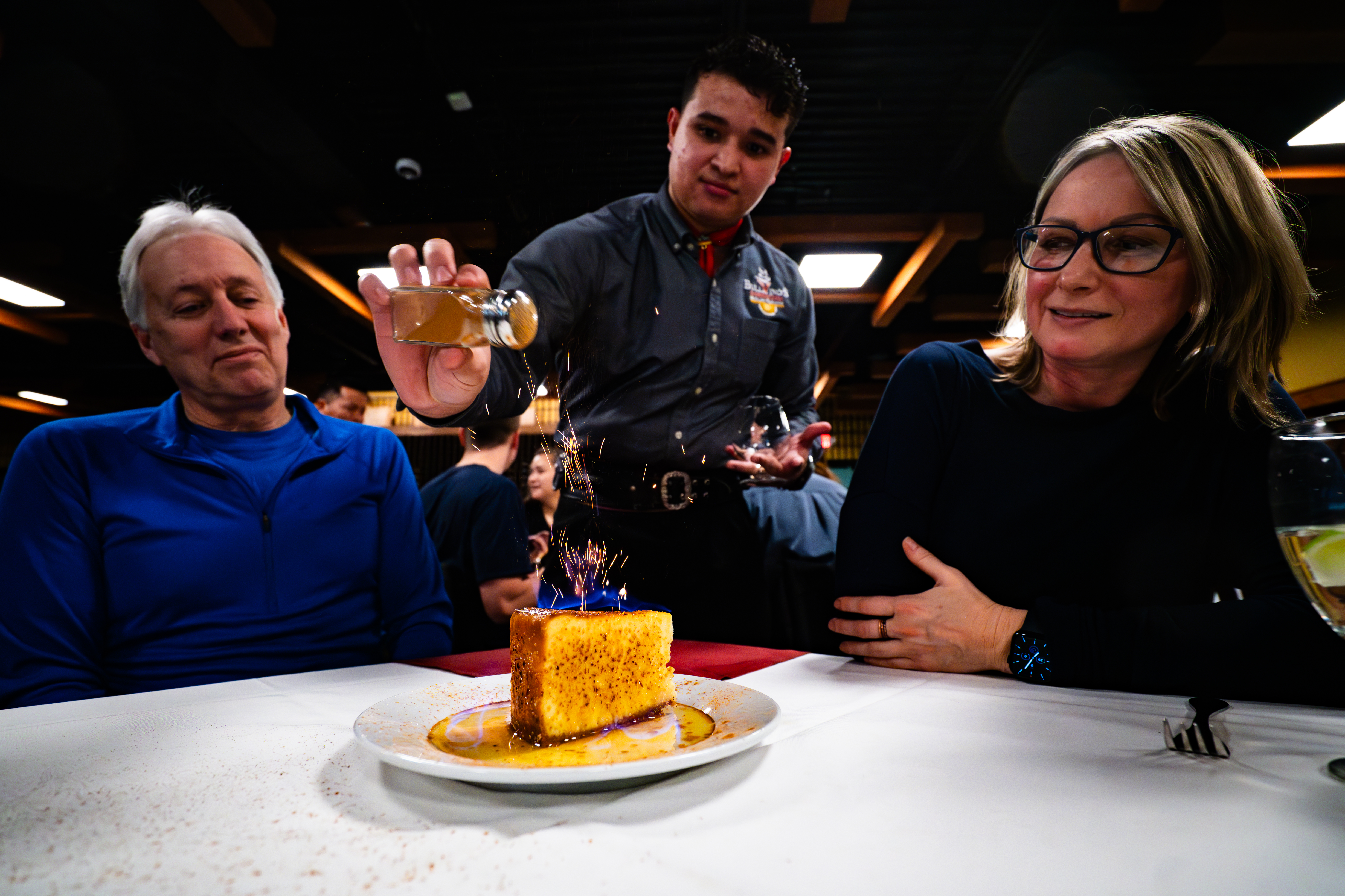a couple of people sitting at a table with a cake