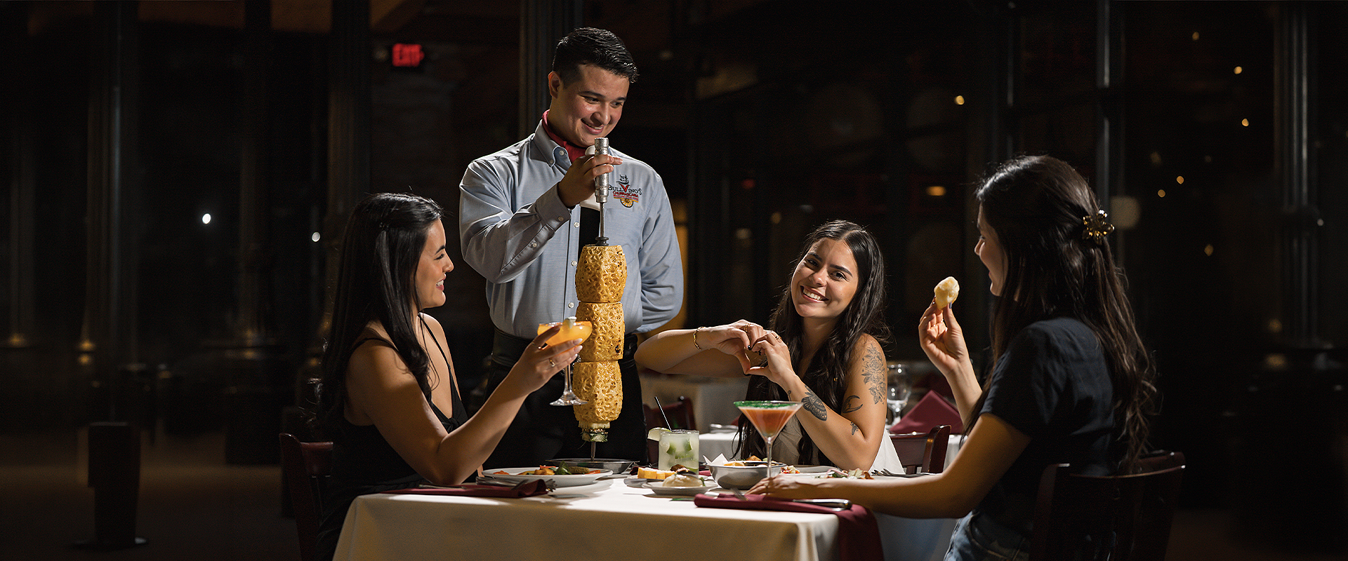 a man pouring a drink into a couple of women