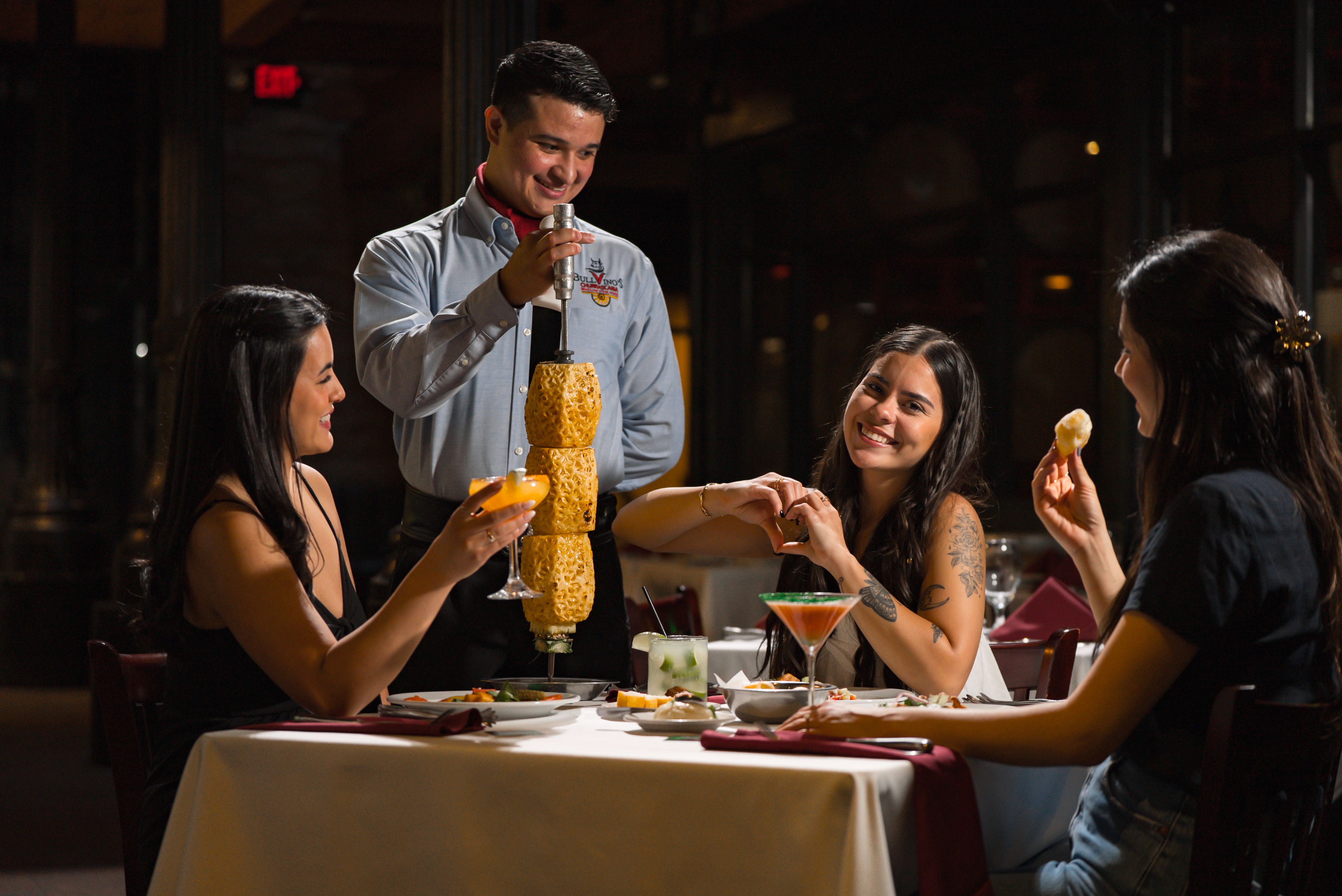 a man pouring a drink into a couple of women