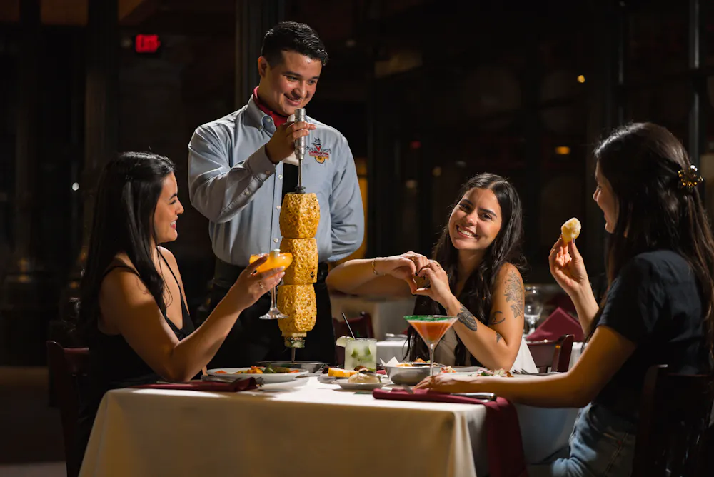 a man pouring a drink into a couple of women