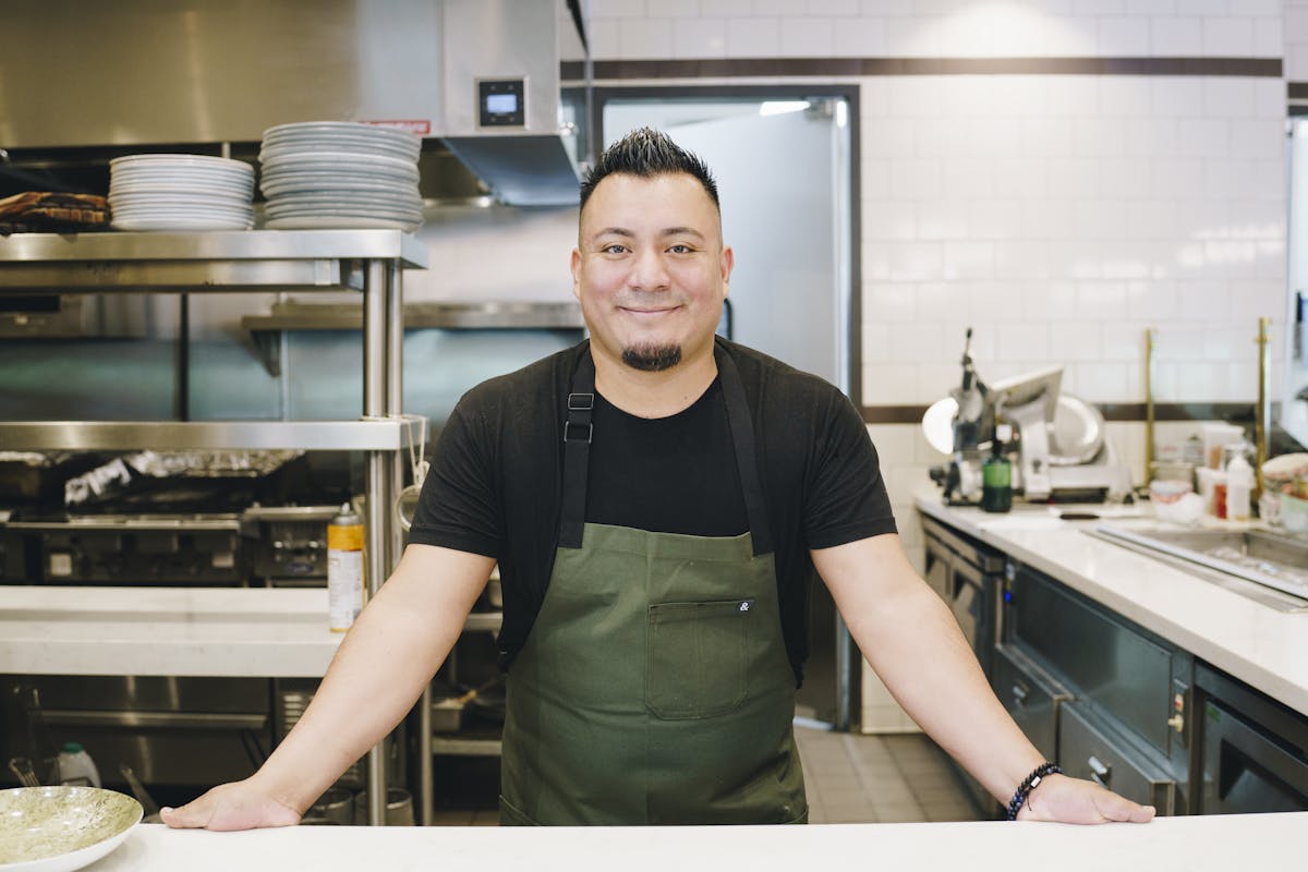 a smiling man in a kitchen preparing food