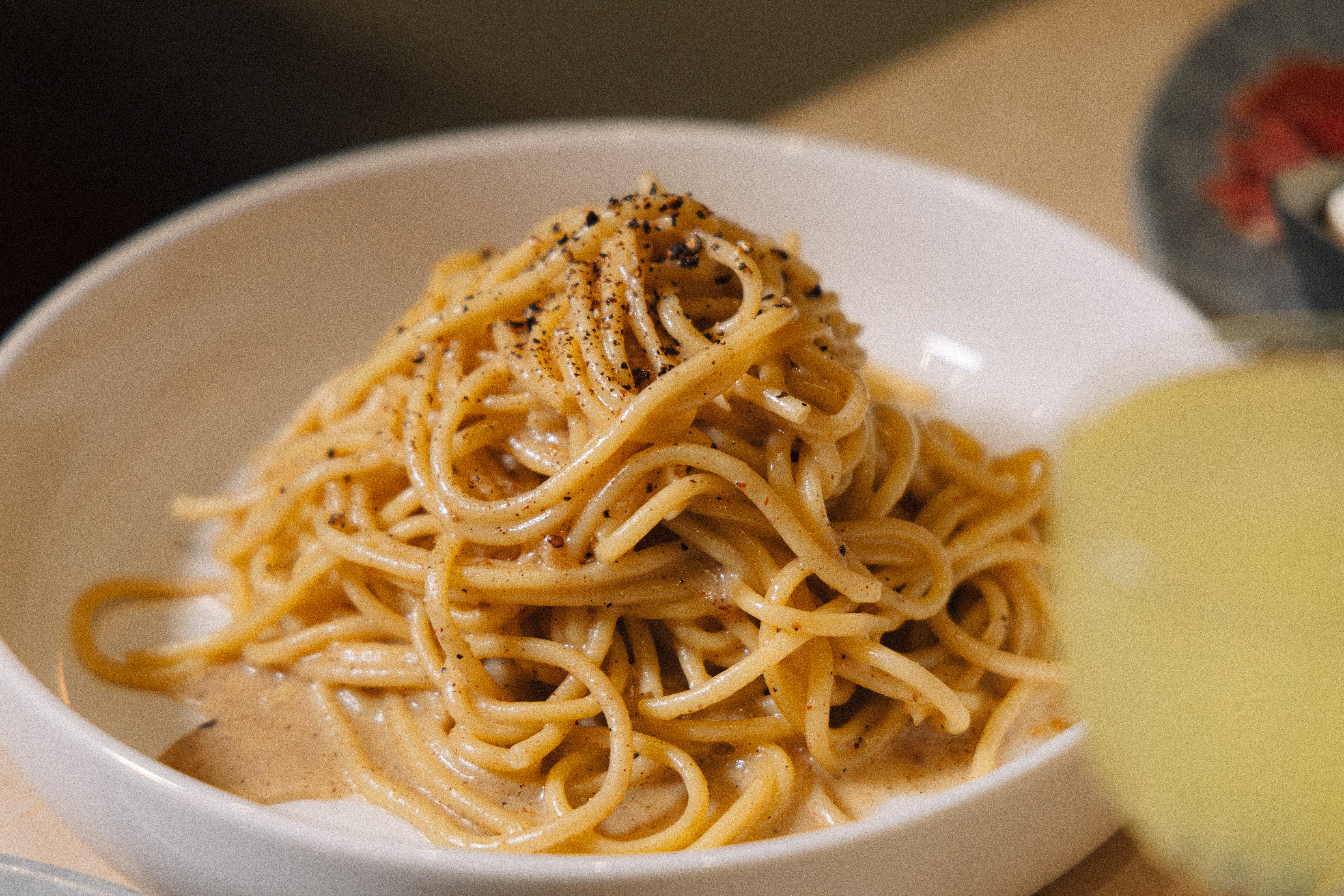 a bowl of pasta sits on a plate