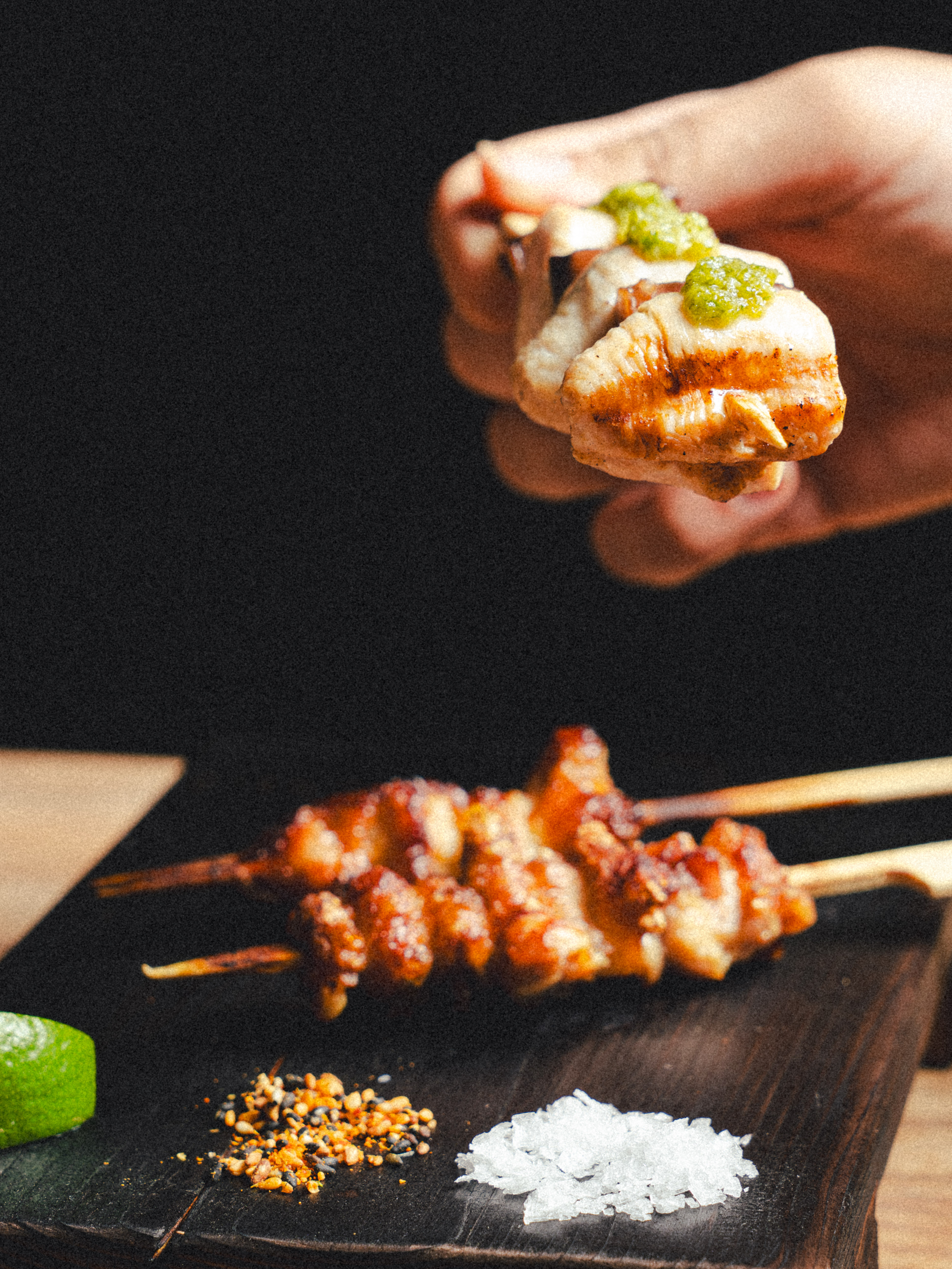a person holding a skewer of food