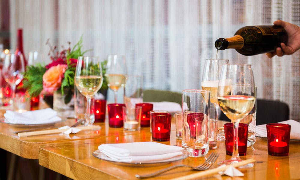 a person sitting at a table with wine glasses