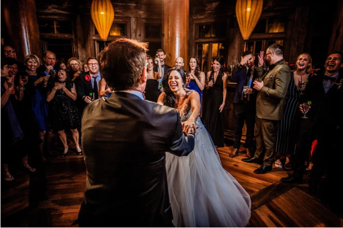 a man and woman dancing in a room with people