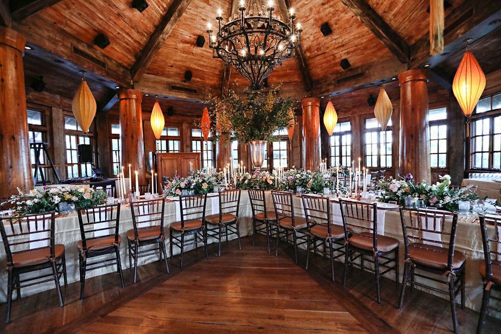 a room with a table set with chairs and flowers