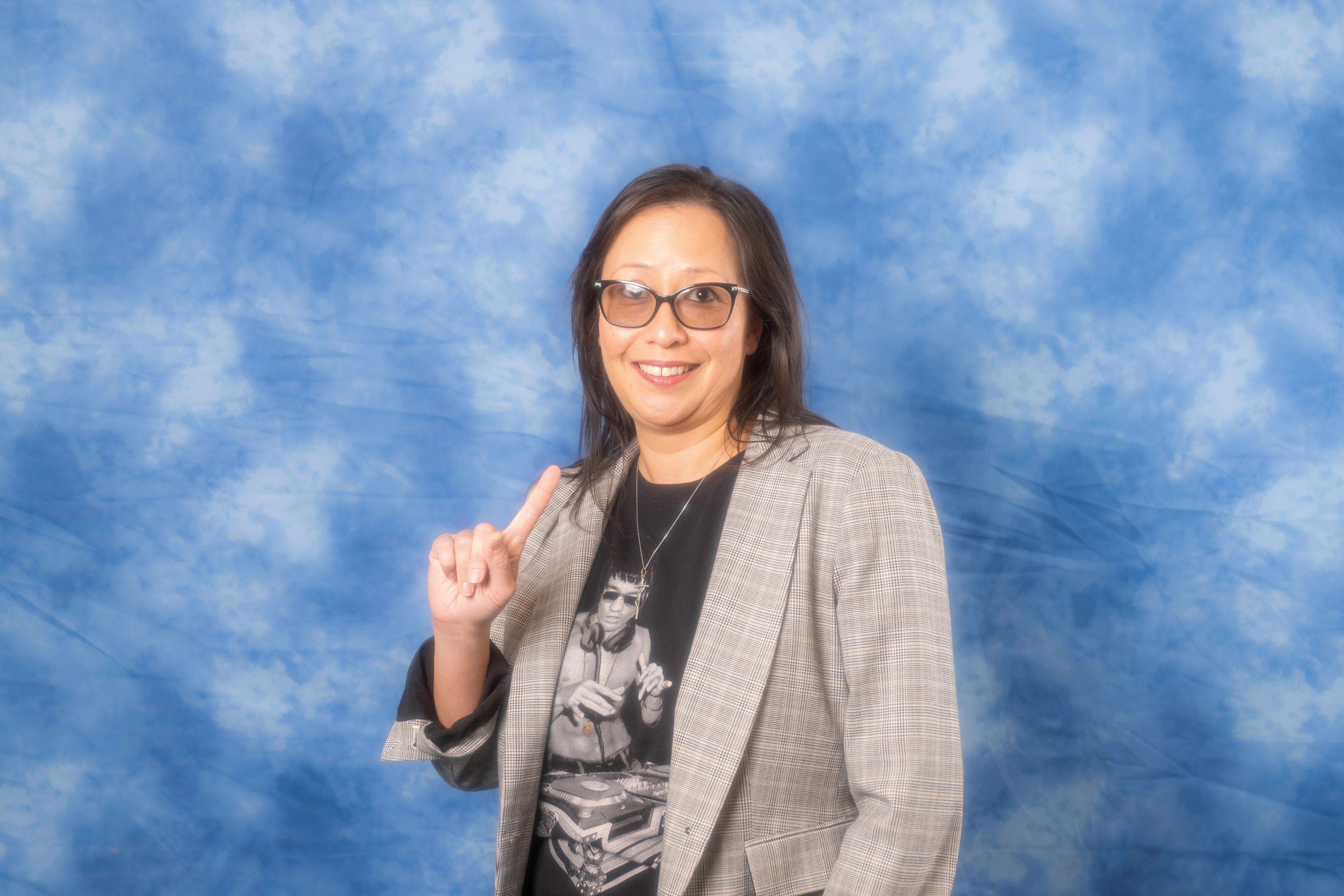 a woman wearing glasses and smiling at the camera